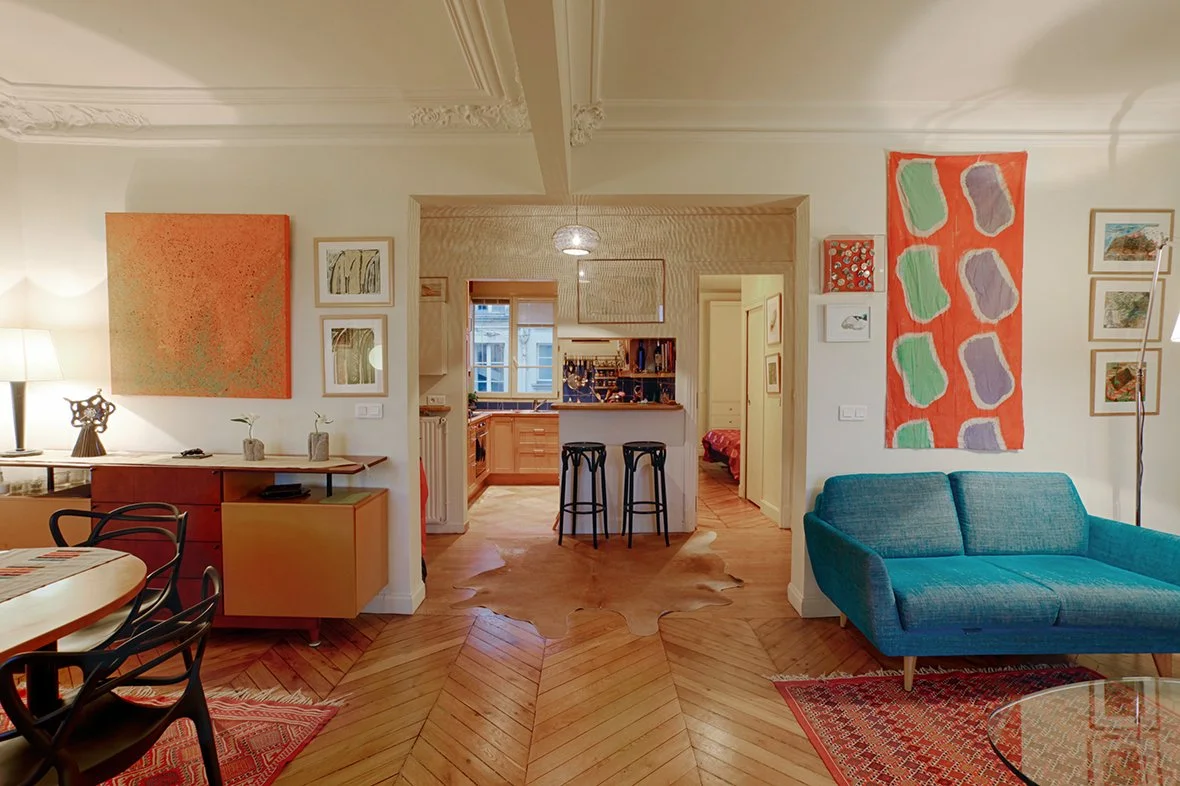 Vue de la cuisine et d'une chambre avec parquet point de Hongrie et moulures dans un appartement Haussmannien du 10ème arrondissement  