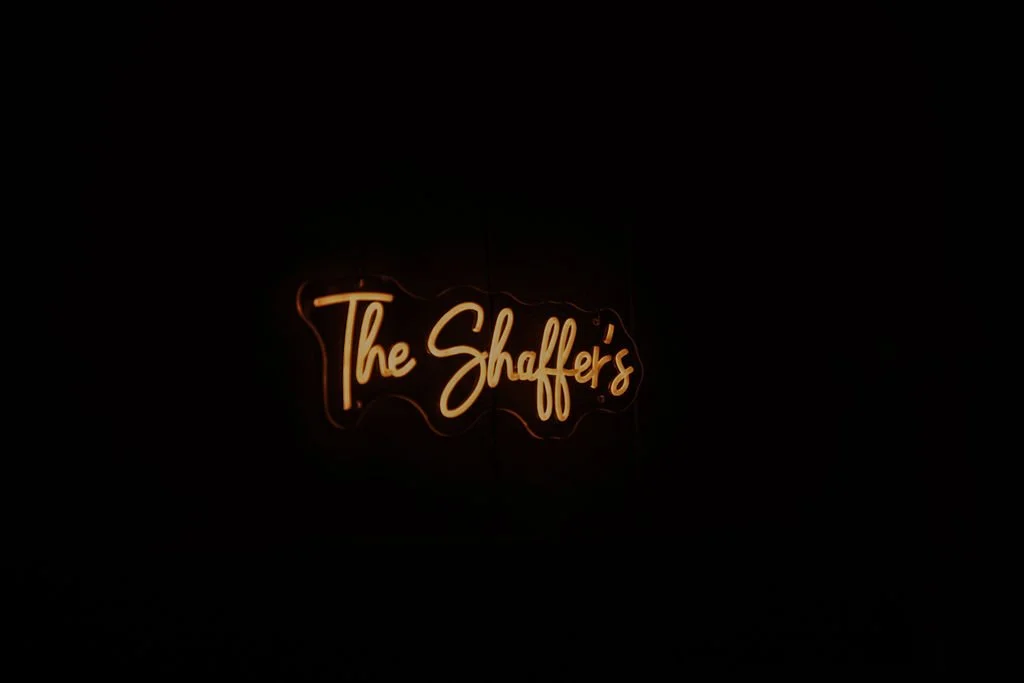 Neon sign reading 'The Shaffer's' in cursive font against a black background.