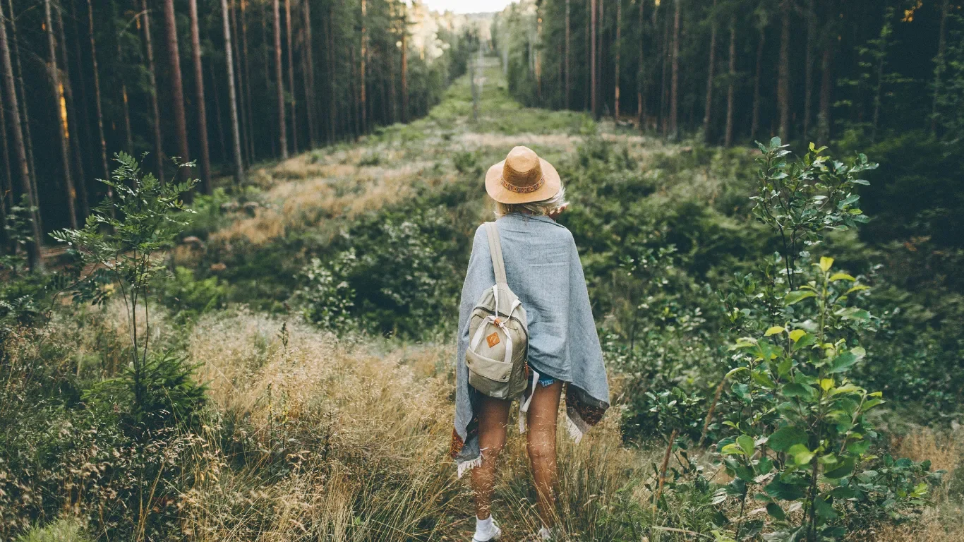 Woman walking through forest path, clinical supervision for therapists Rhode Island.