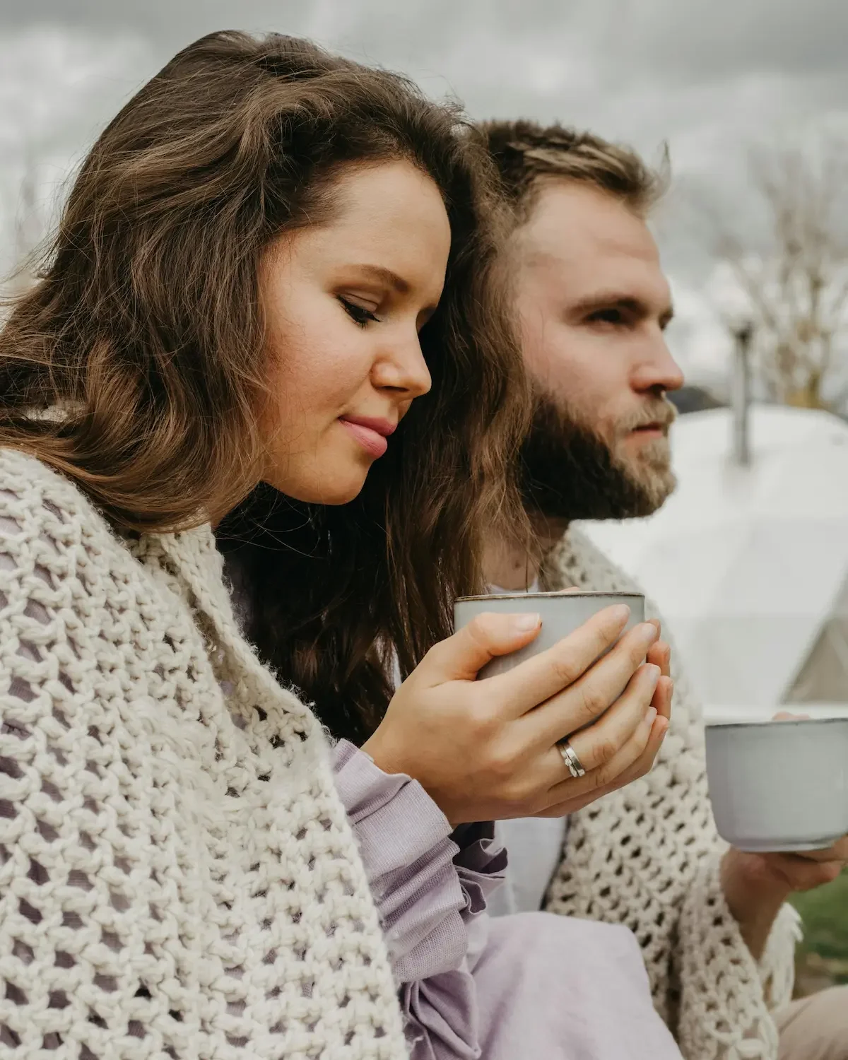 Couple sitting close outdoors with mugs, relationship counseling East Greenwich RI.