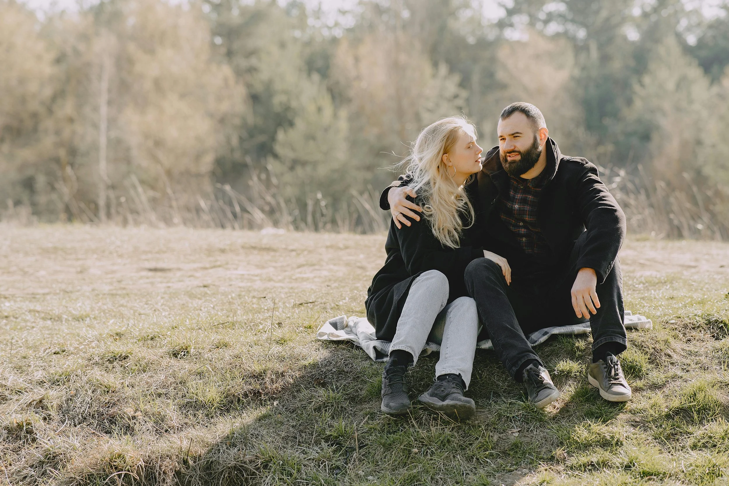 Couple sitting close in field, strengthening intimacy therapy East Greenwich RI