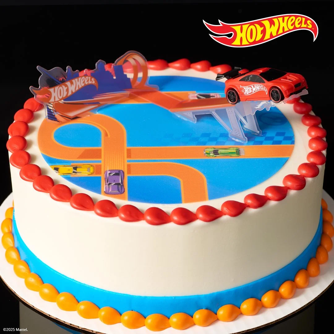 Hot Wheels themed birthday cake with car decorations and race track design on top.