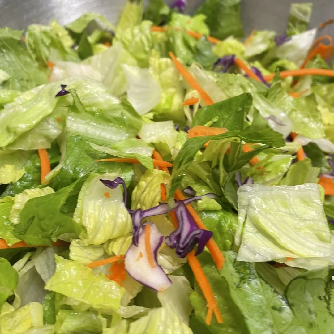 Close-up of a fresh mixed salad with lettuce, shredded carrots, and purple cabbage.