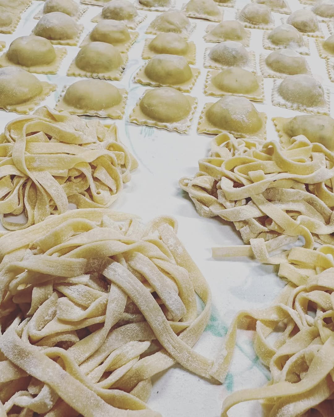 Fresh homemade pasta and gnocchi made from dough, arranged on a surface, ready for cooking.