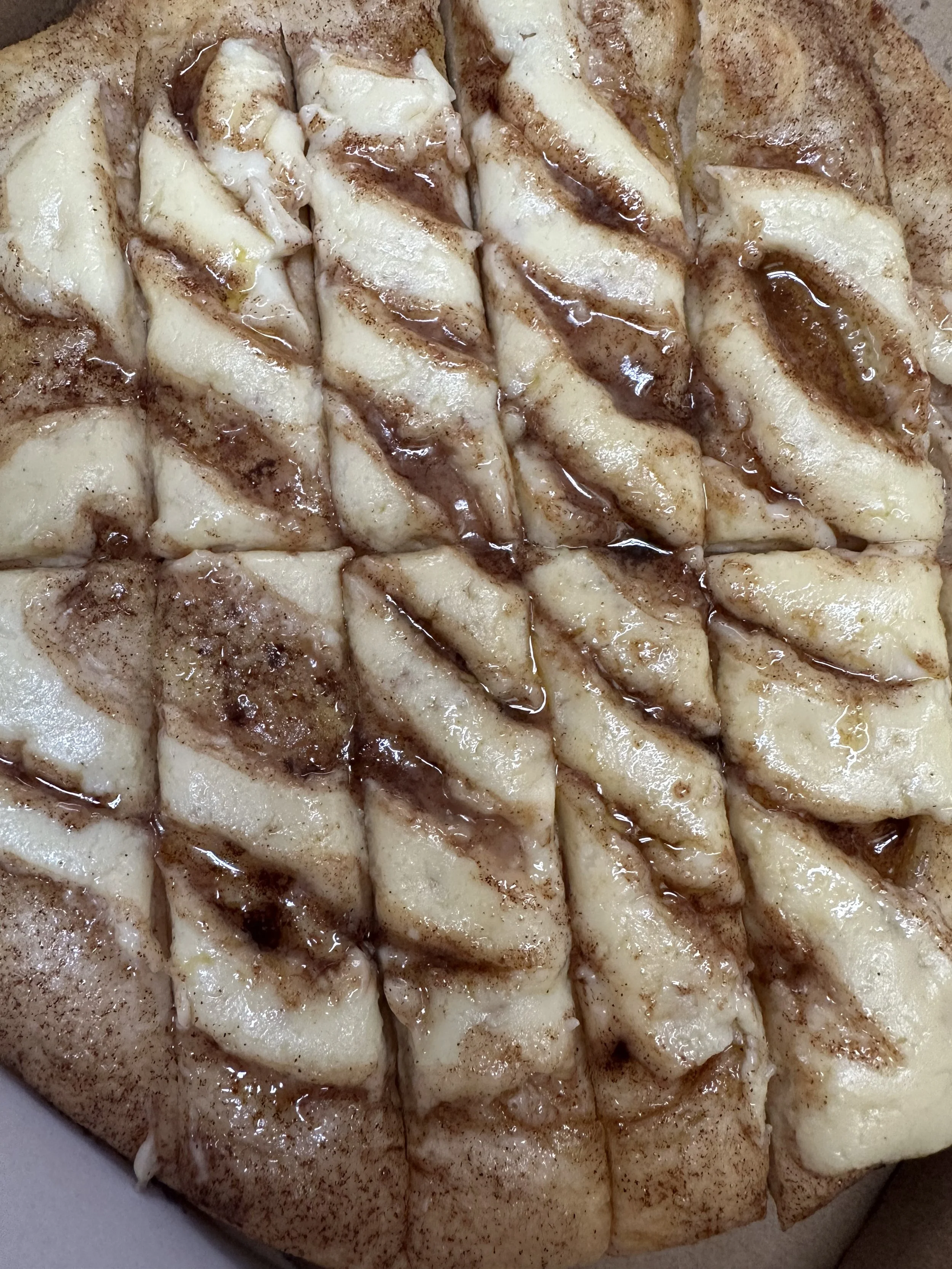 Close-up photo of slices of apple pie with cinnamon topping and drizzled syrup.