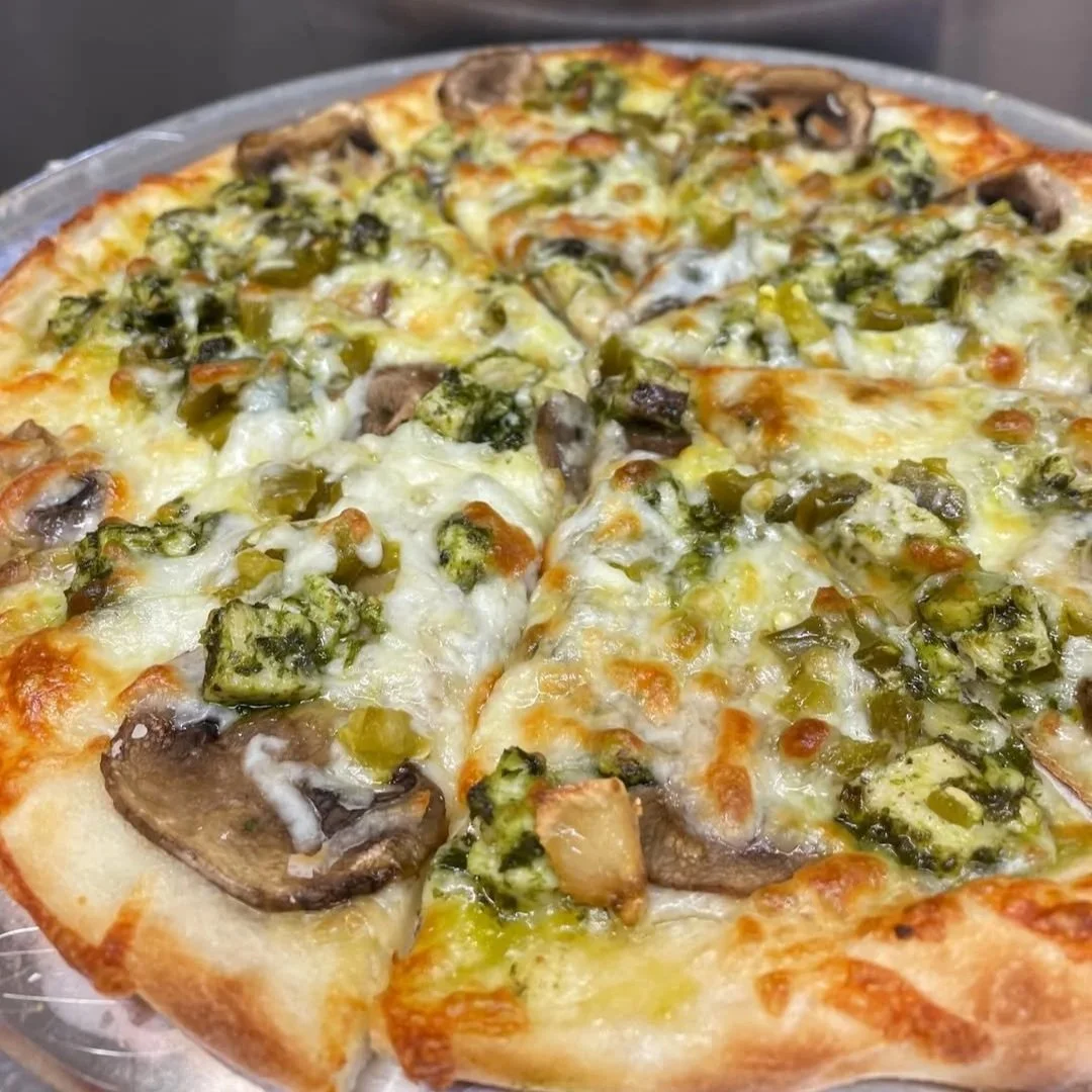 Vegetarian pizza topped with mushrooms, green peppers, and green olives.