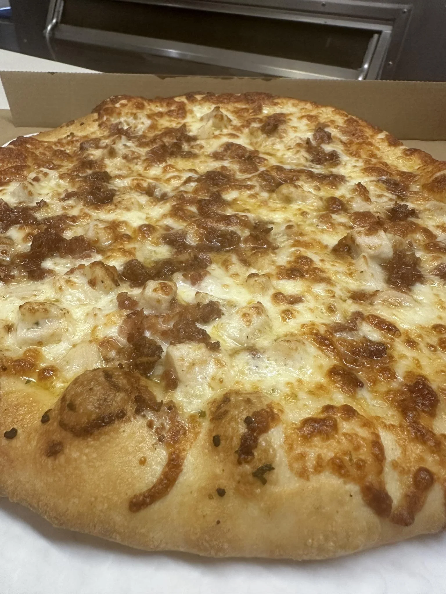 A close-up of a slice of pepperoni pizza in a cardboard pizza box.