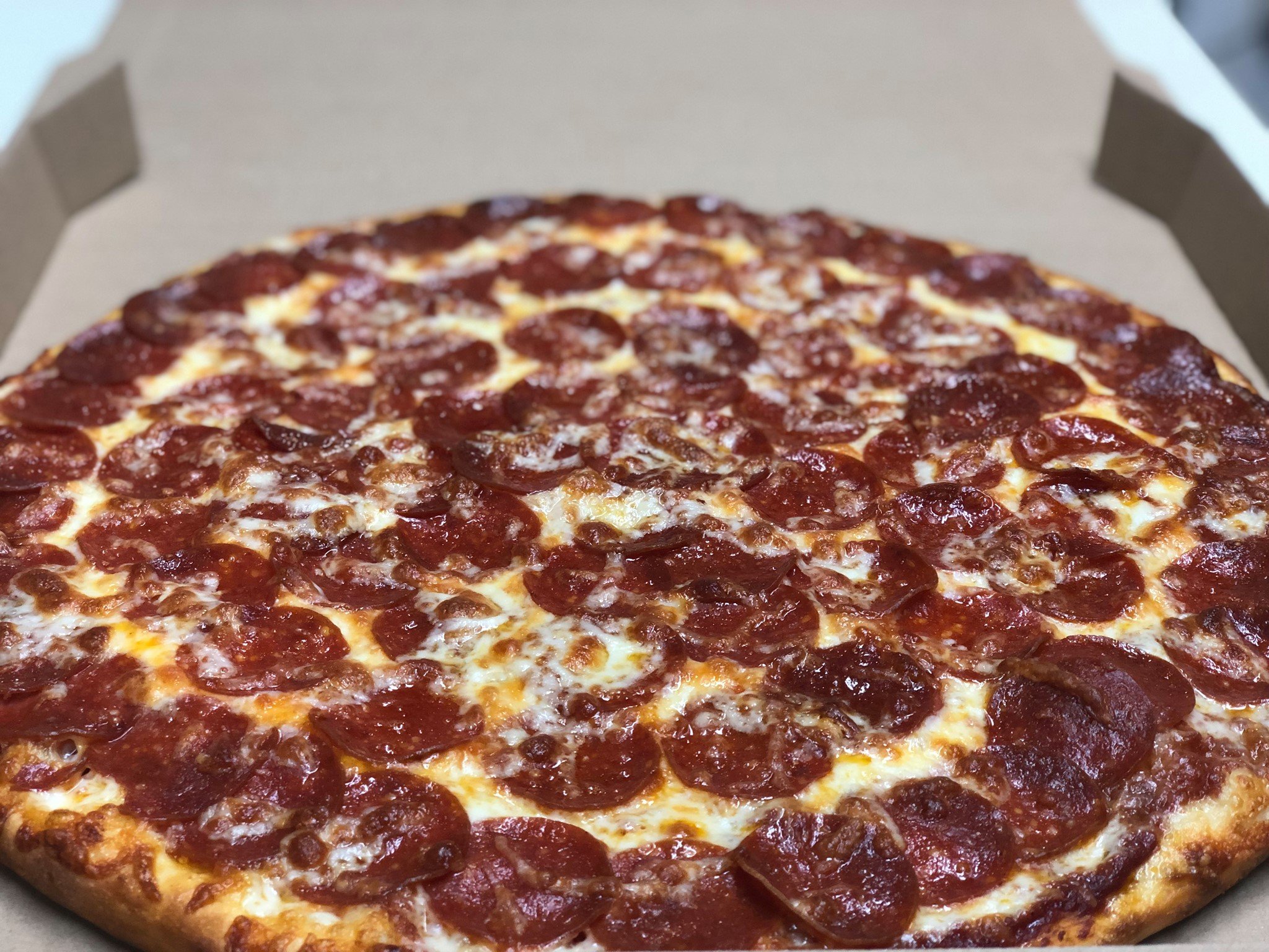 Pepperoni pizza in a cardboard box.