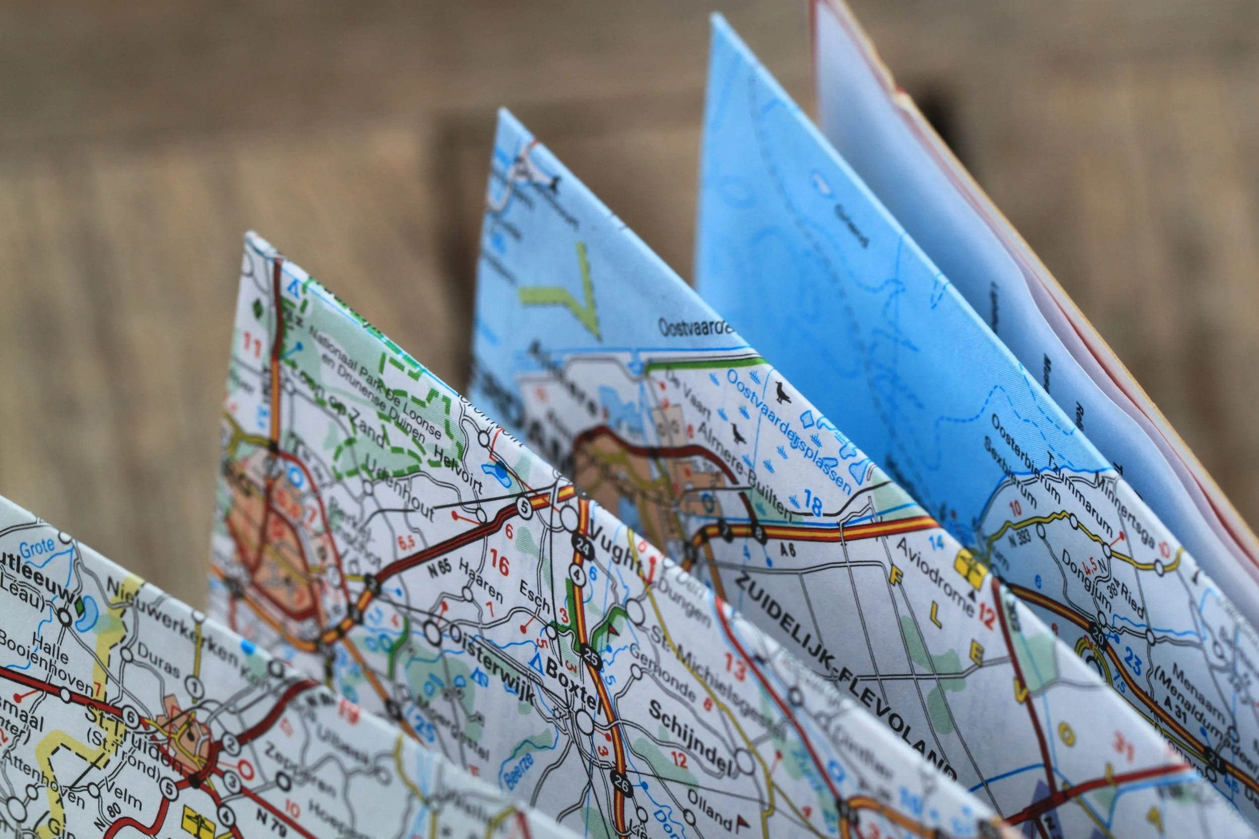 Close-up of folded paper maps showing roads, waterways, and place names in Holland.