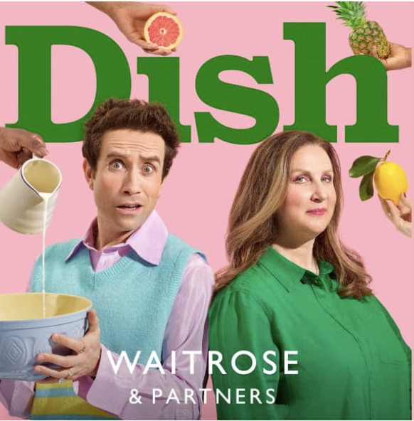 A promotional poster featuring a man and woman with a pink background and the word 'Dish' in large green letters. The man is holding a bowl with a yellow liquid, and various fruits and liquids are being poured into the scene, including grapefruit, pineapple, milk, and lemon. The man looks surprised, and the woman has a confident expression. The text at the bottom reads 'Waitrose & Partners'.