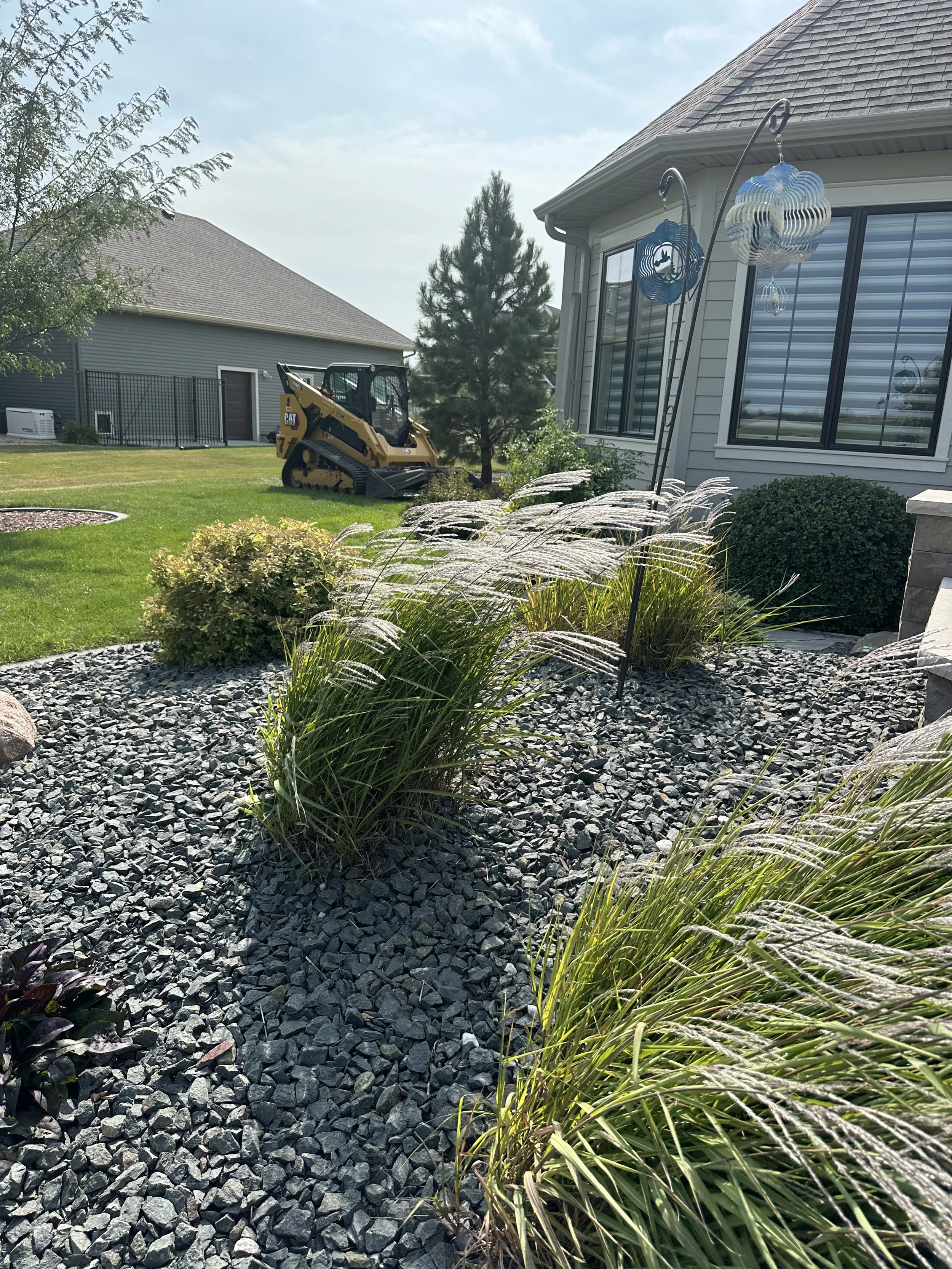 A skid-steer loader with an orange and white body clearing snow in a snowy outdoor area.
