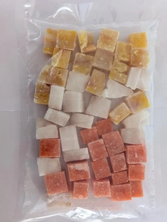 Assorted frozen fruit cubes in clear plastic bag, including yellow, white, and pink/orange pieces.