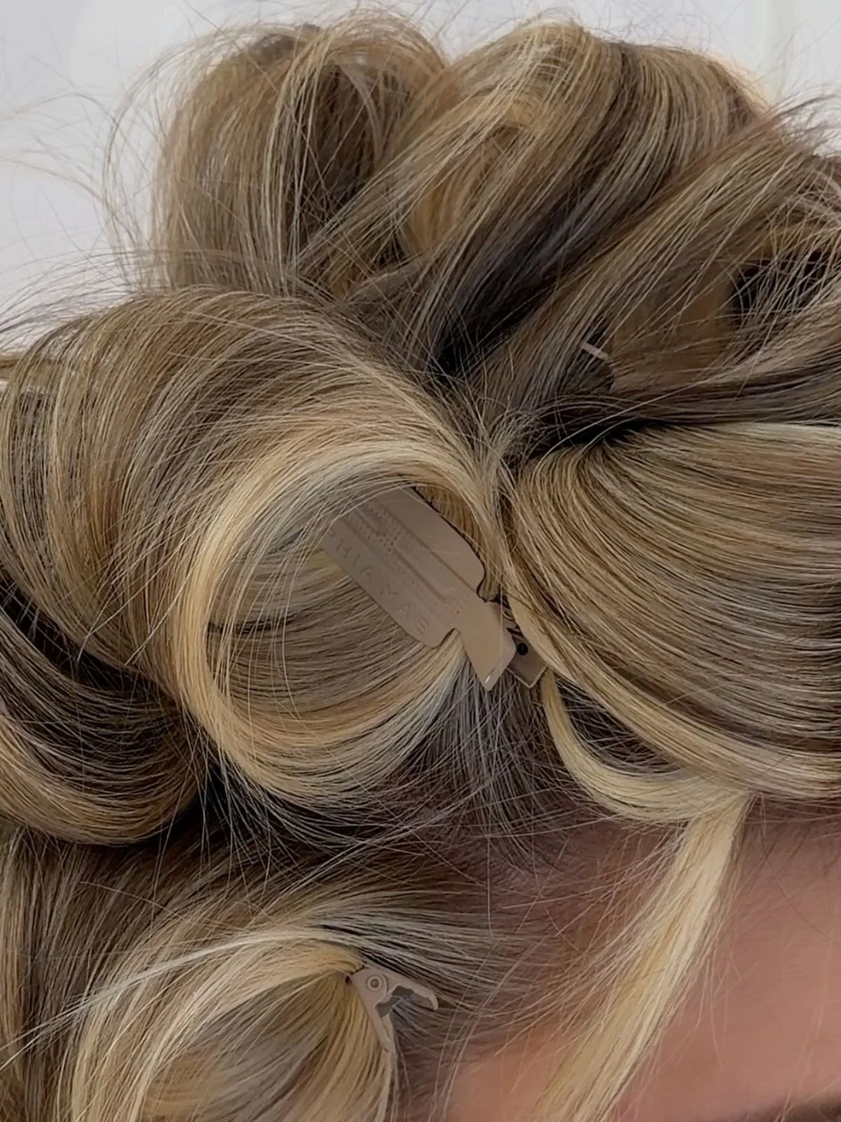 Close-up of blonde hair rollers with blonde hair in them.