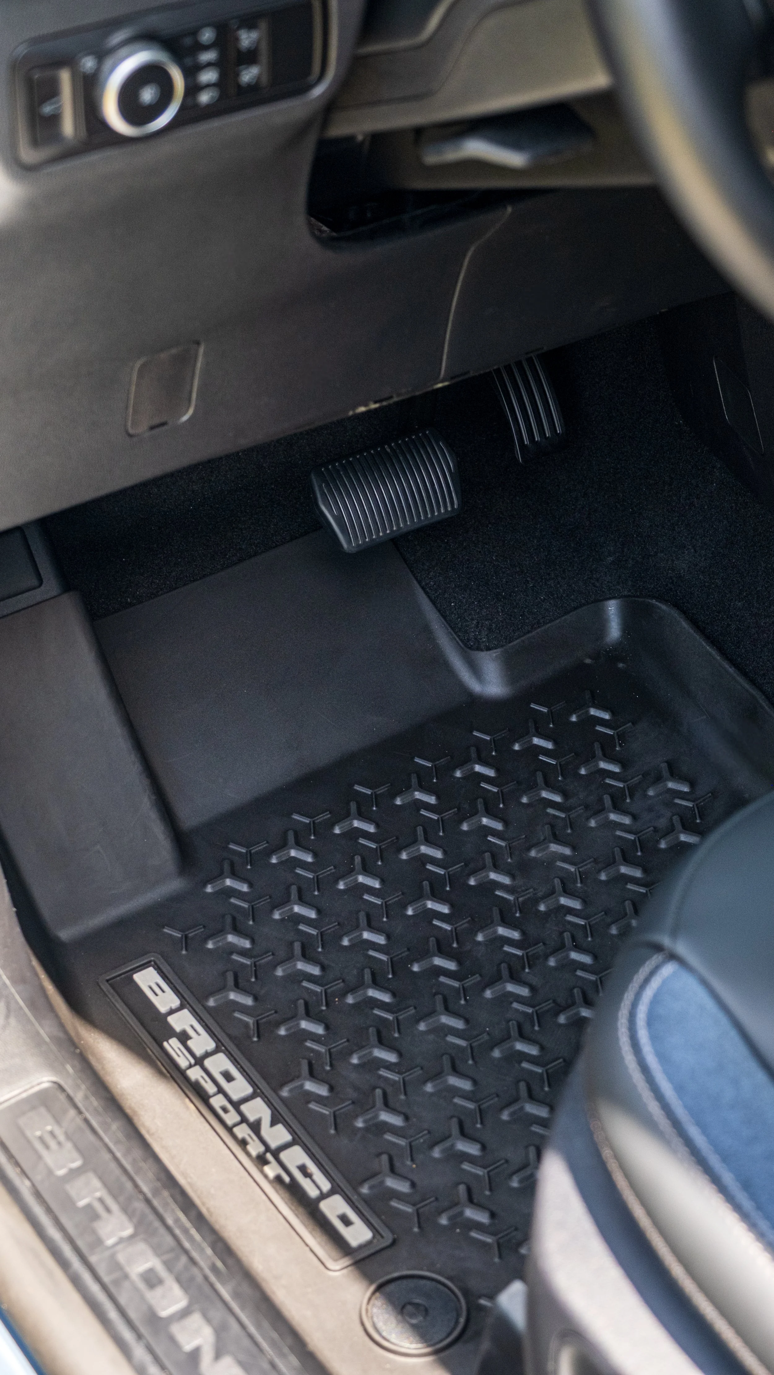Close-up view of the rubber floor mat and accelerator and brake pedals inside a Ford F-150 truck.