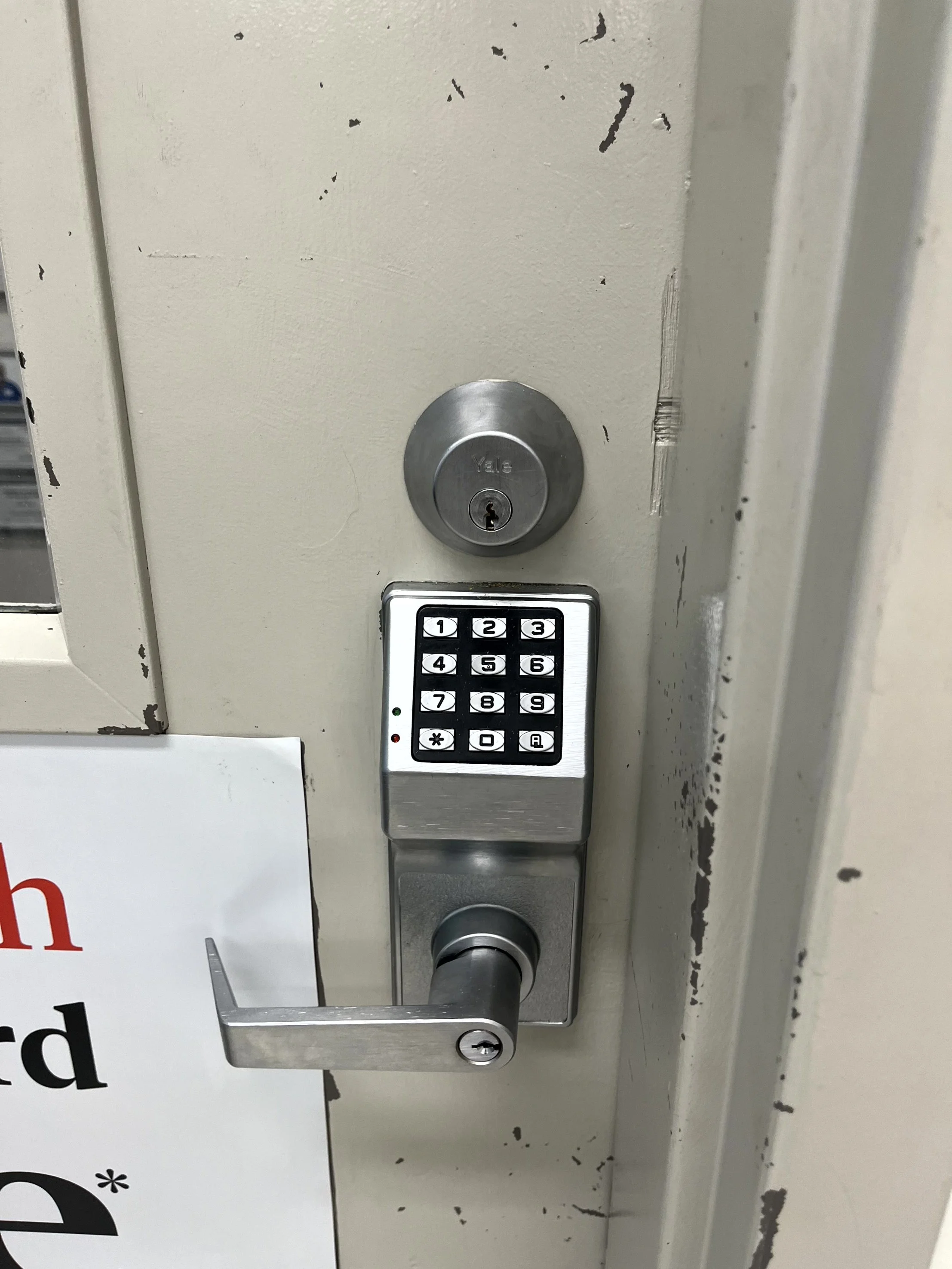 Door with a keypad lock and a circular door handle above it.