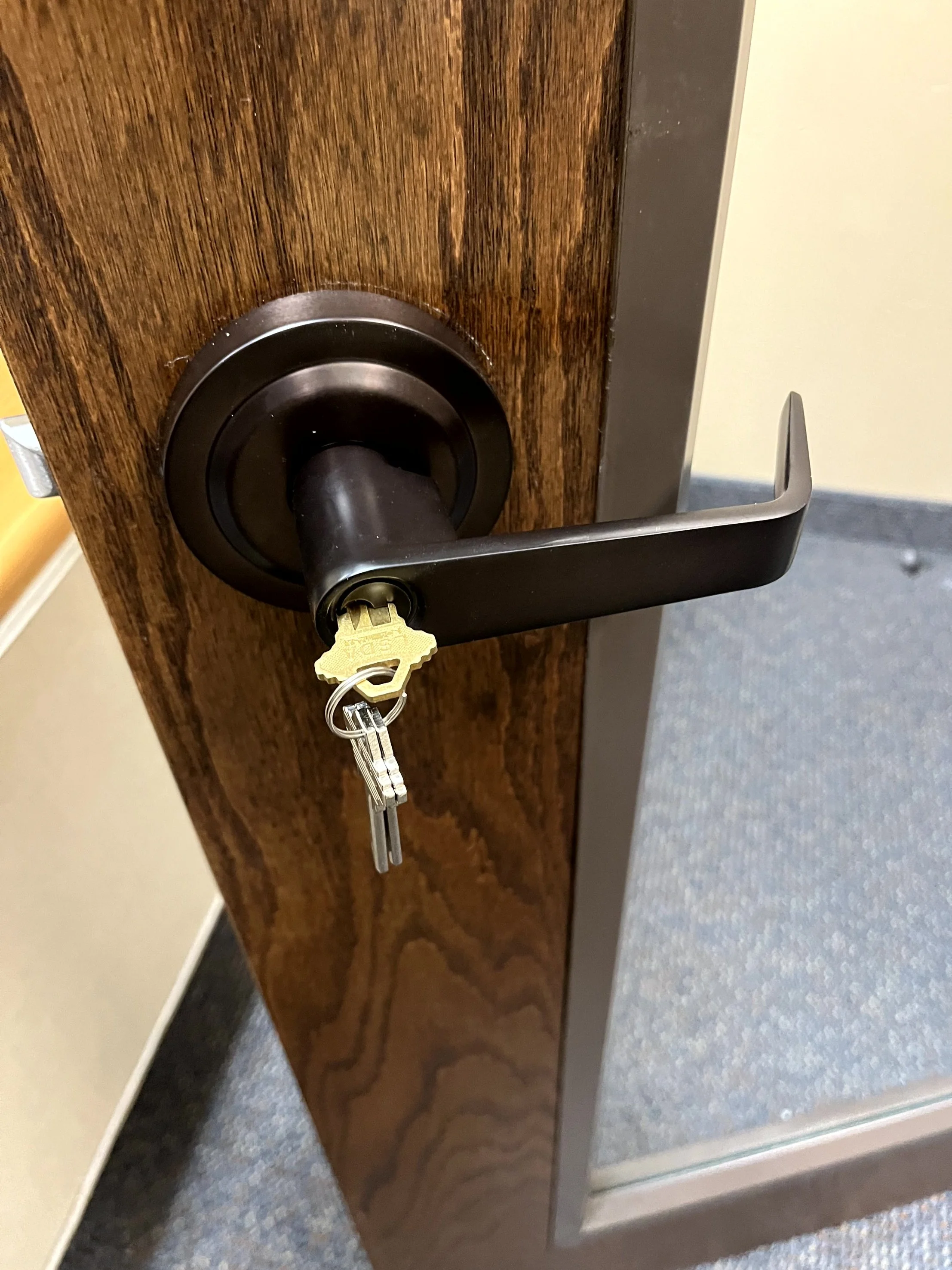 Door with a black handle and a key inserted in the lock