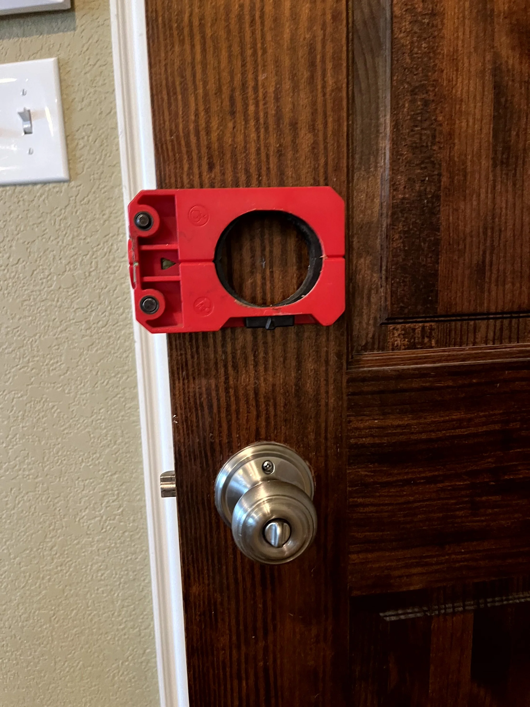 A door with a doorknob and an orange level placed on the door's surface.