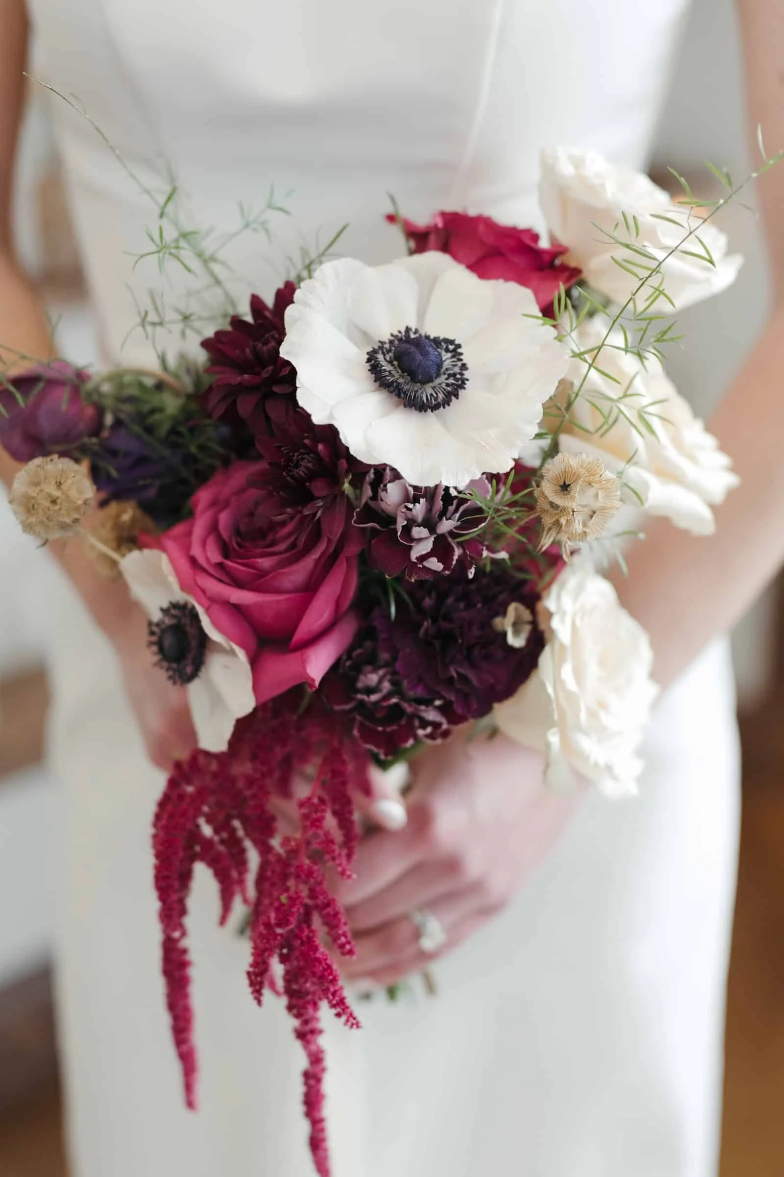 Award-winning florist designs a bouquet of mixed flowers including white anemones, pink roses, deep purple flowers, and pink amaranthus for a bride in Post Falls, Idaho