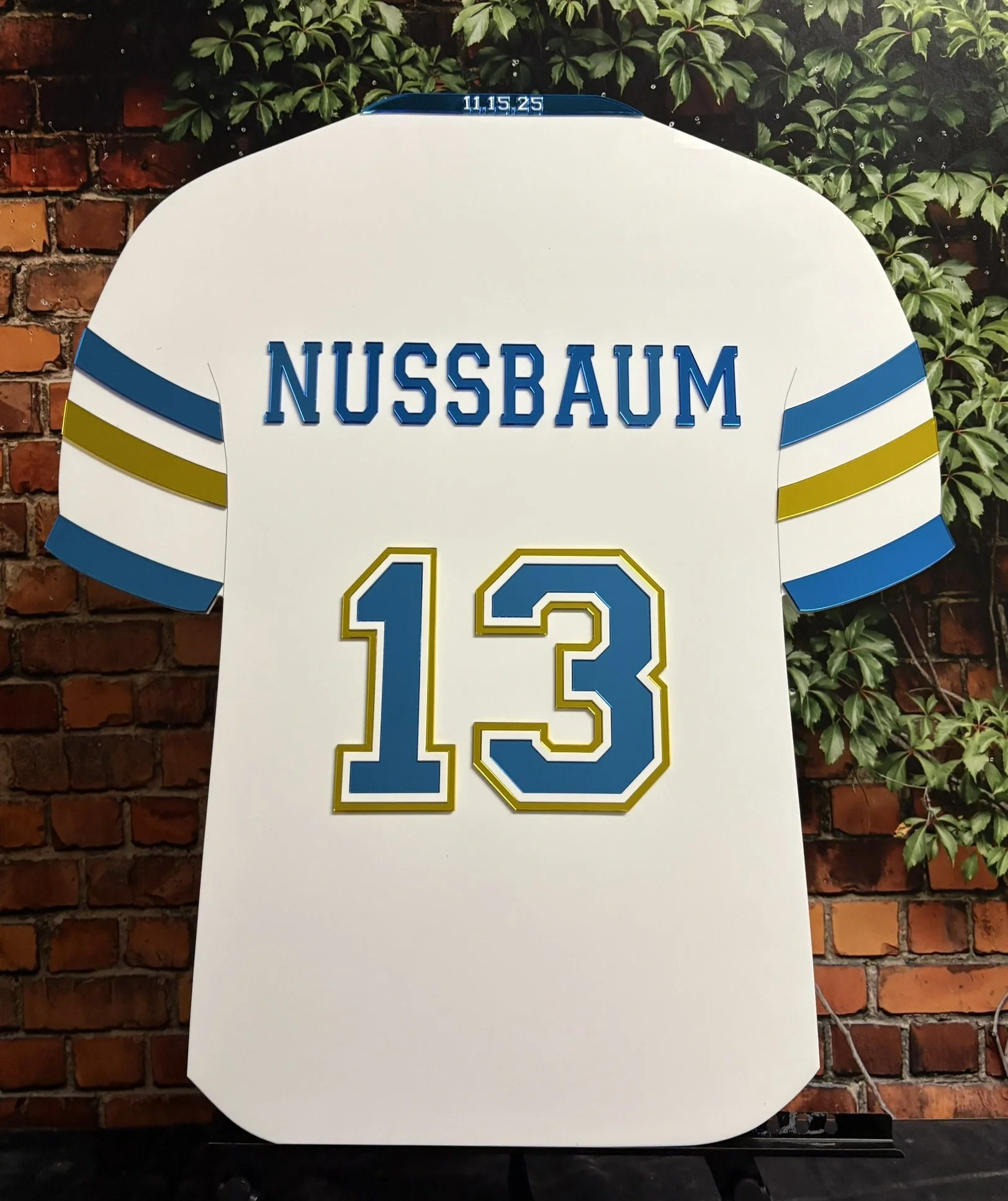 Custom white, blue, and gold football jersey sign-in board. 