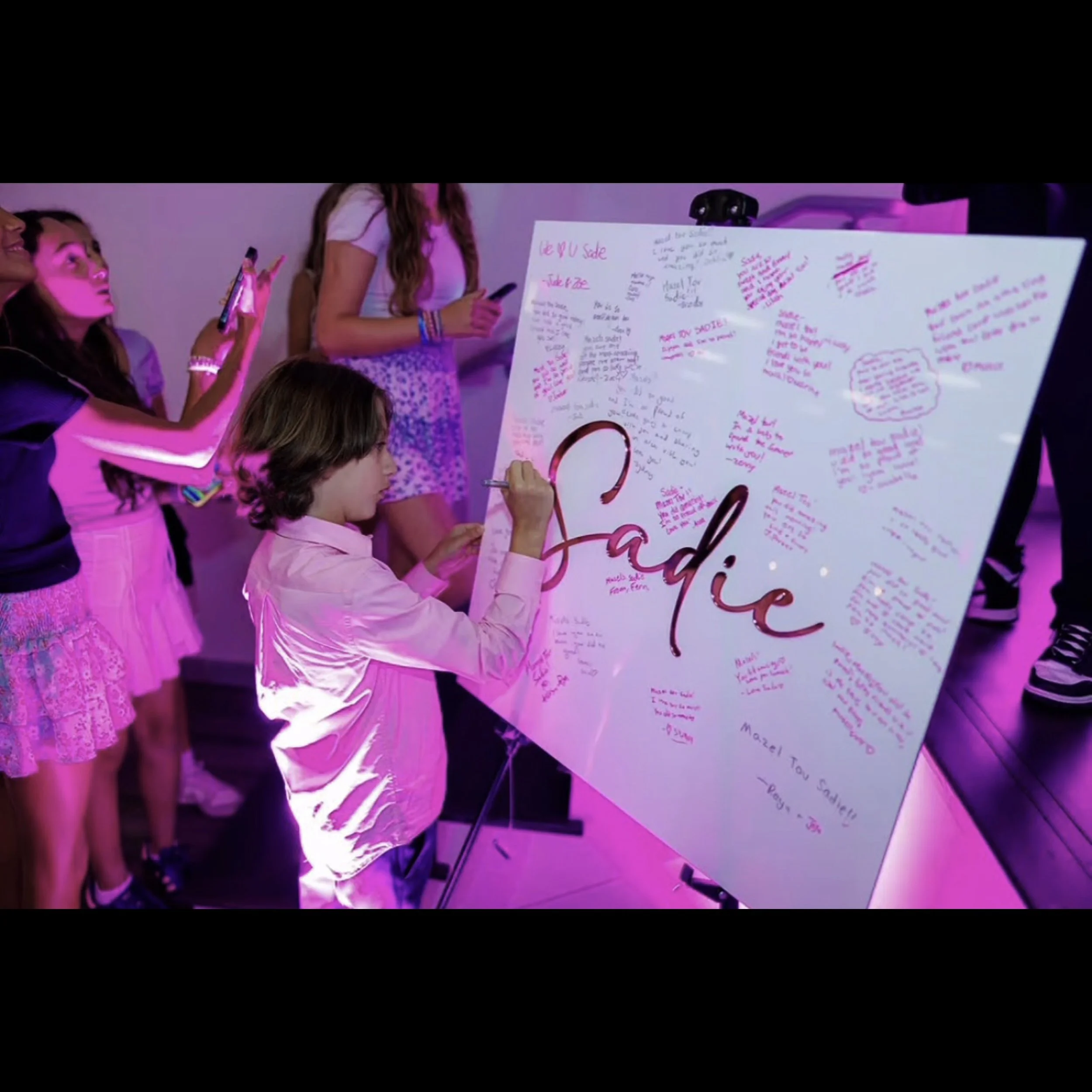 Sadie Pink Text White Board Being Signed.jpg