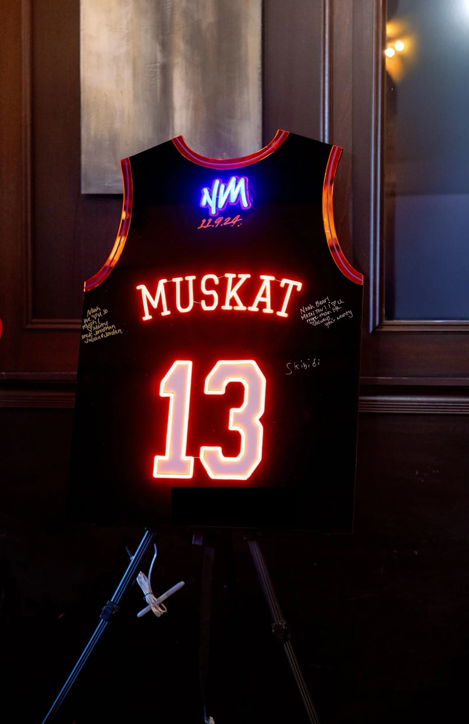 Custom black basketball jersey sign-in board with red and blue neon detailing. 