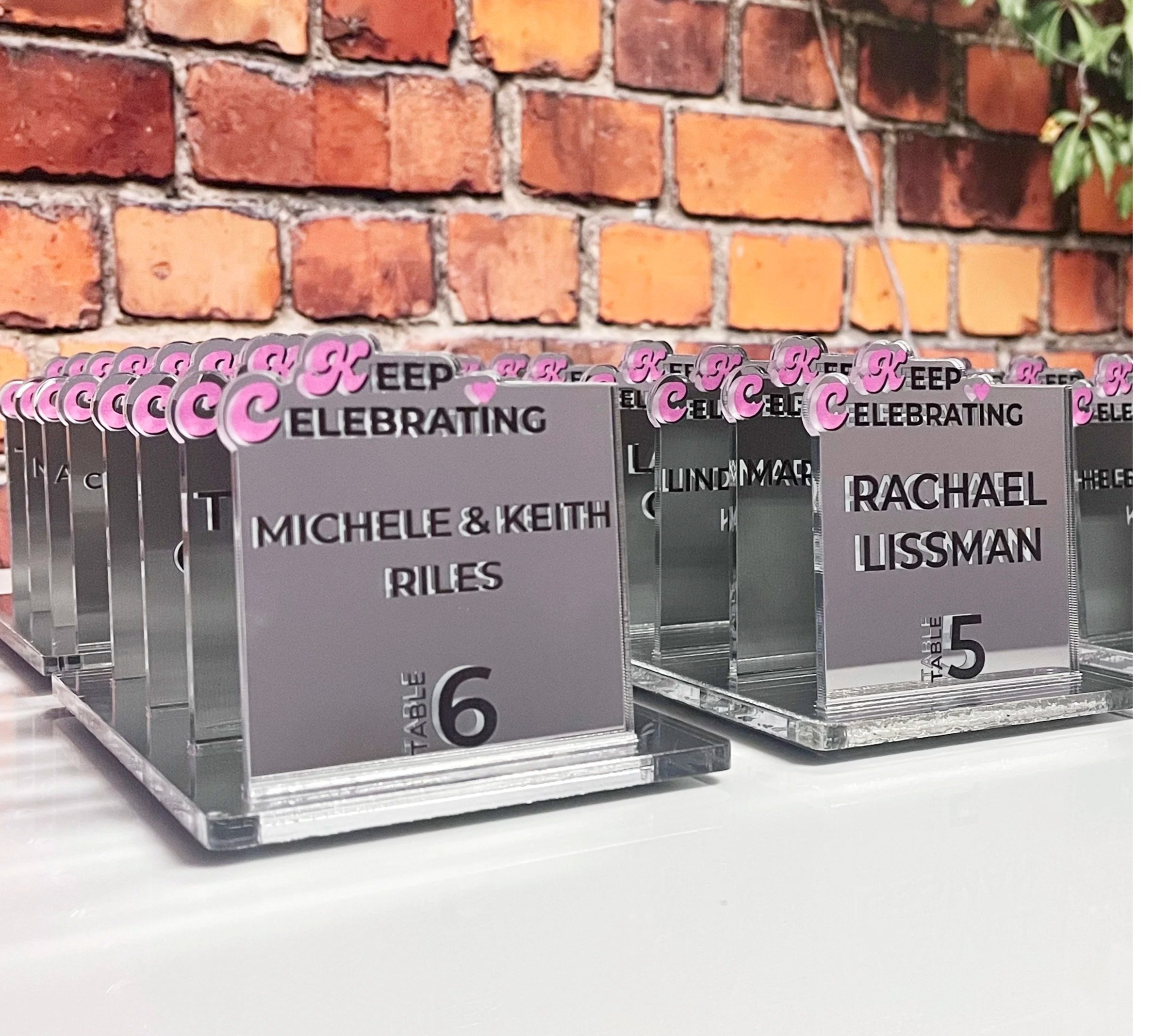 Custom mirrored escort card with pink accent. 