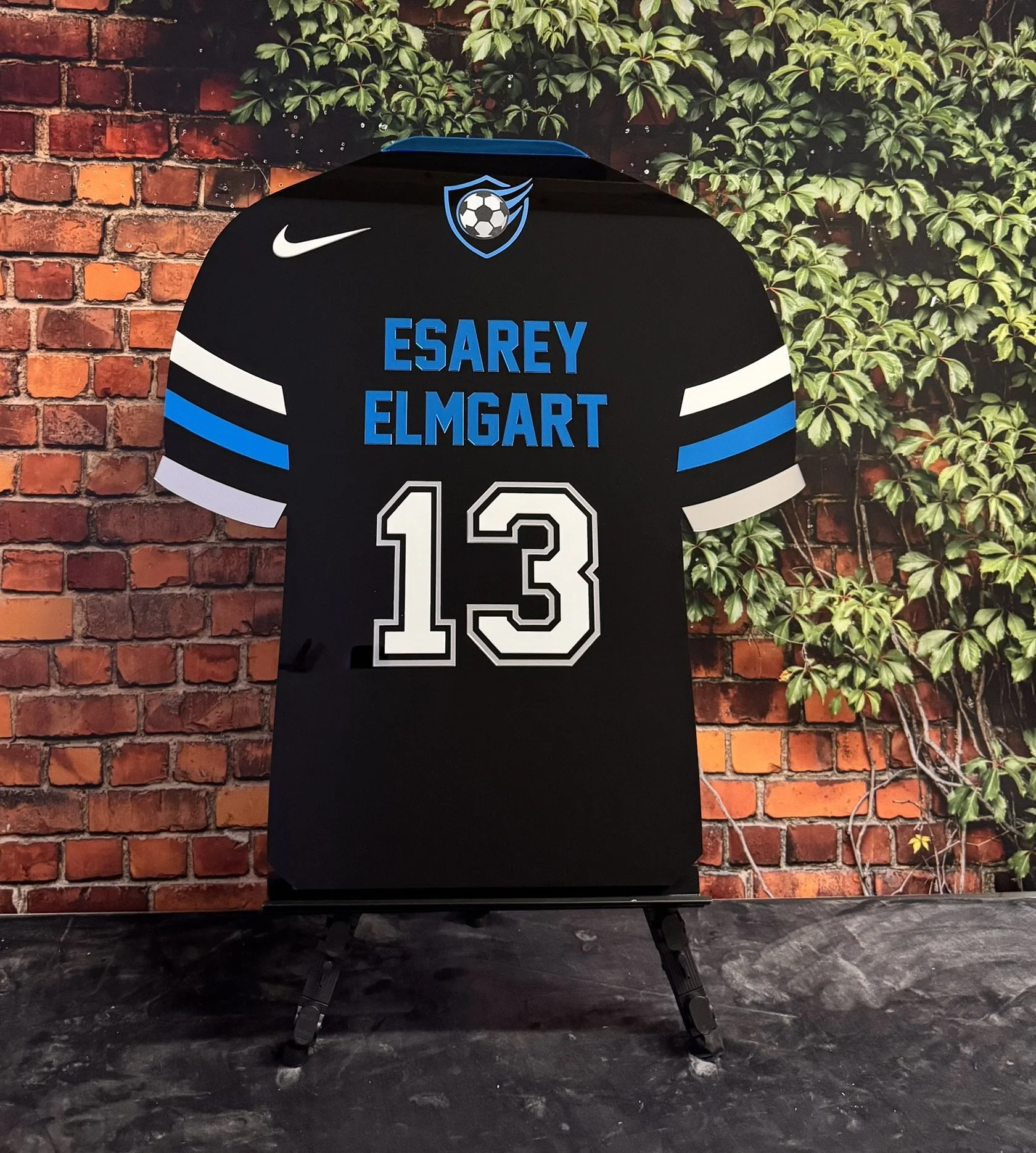 Custom black, blue, and white soccer jersey.