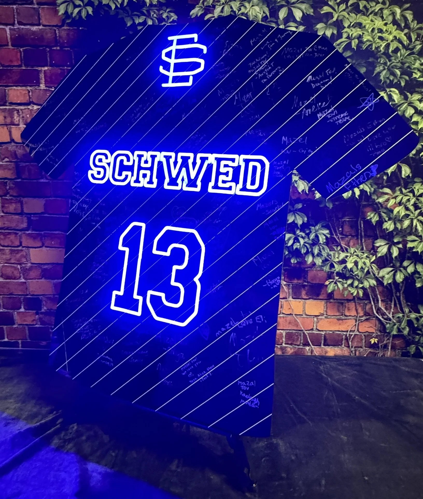 Black baseball jersey sign-in board with diagonal pinstripes and blue neon.
