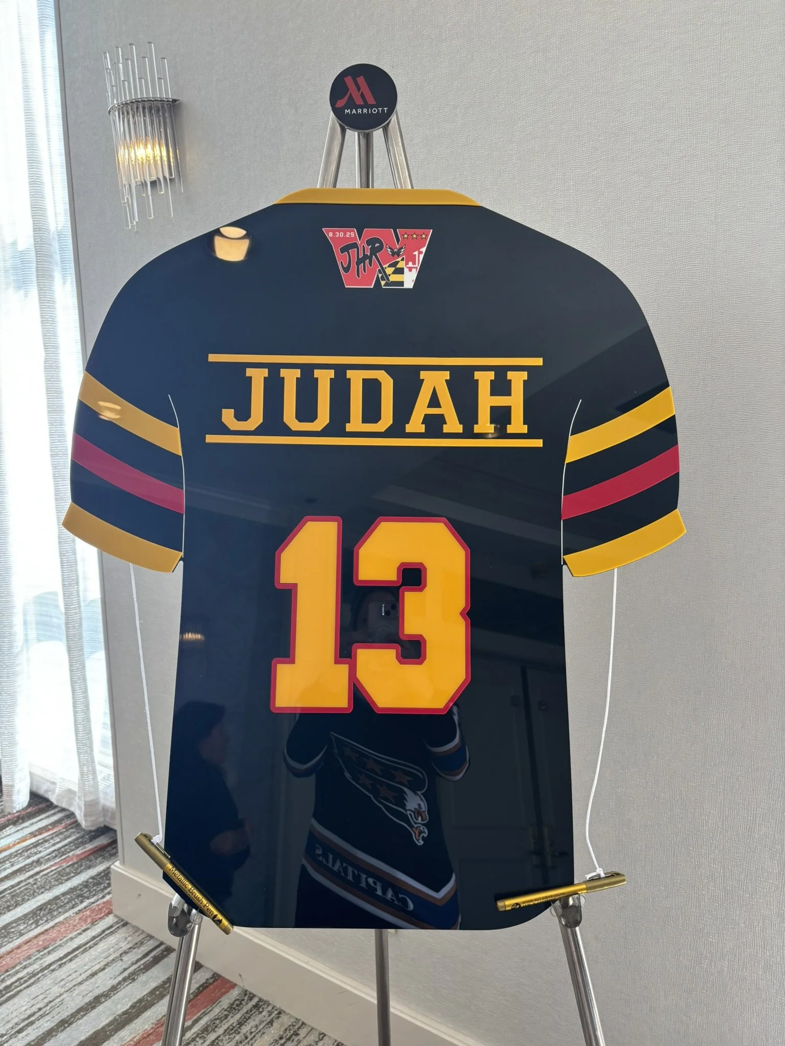 Black custom football jersey sign-in board with red and yellow accents.