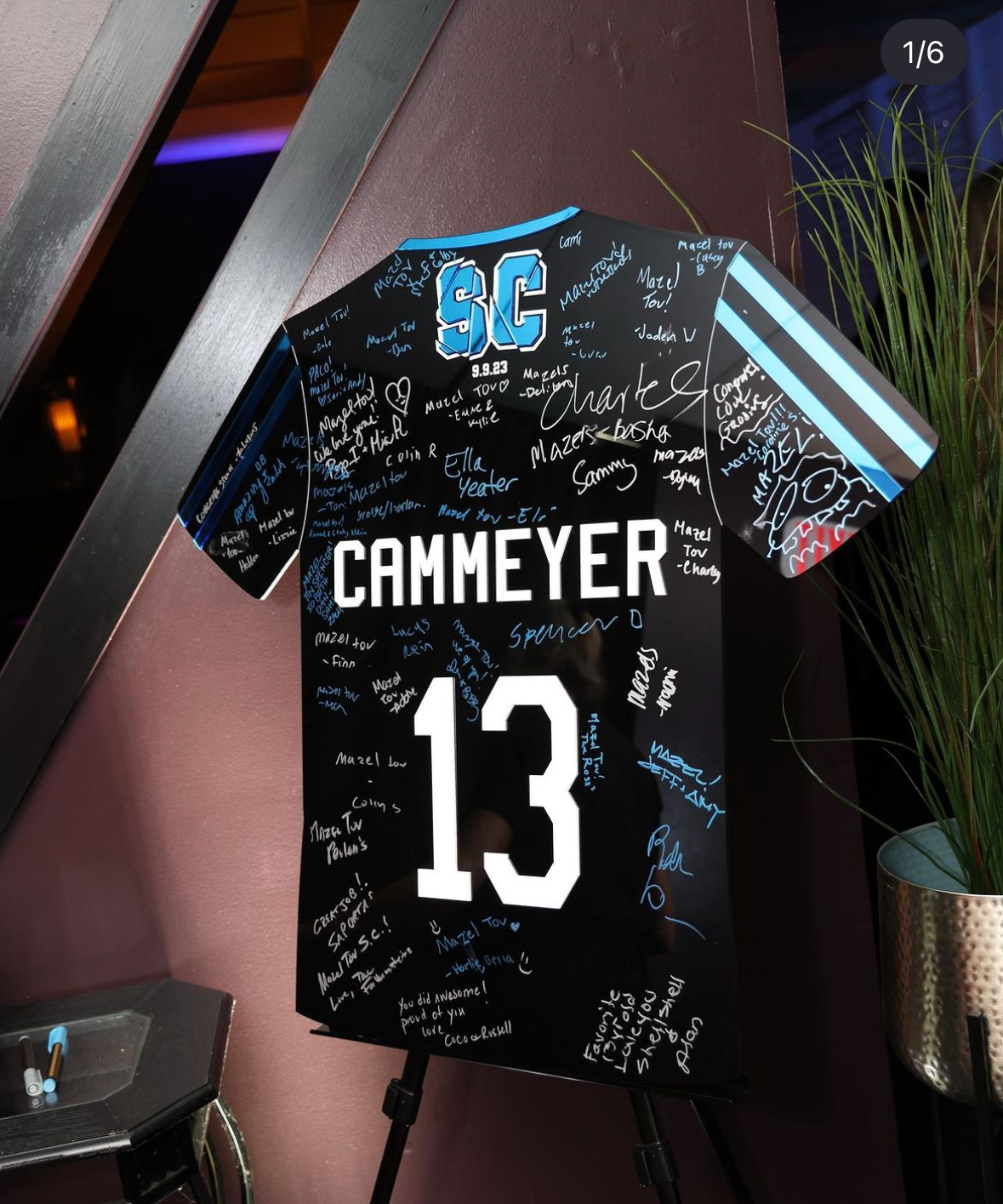 Custom black soccer jersey sign-in board with blue and white accents. 