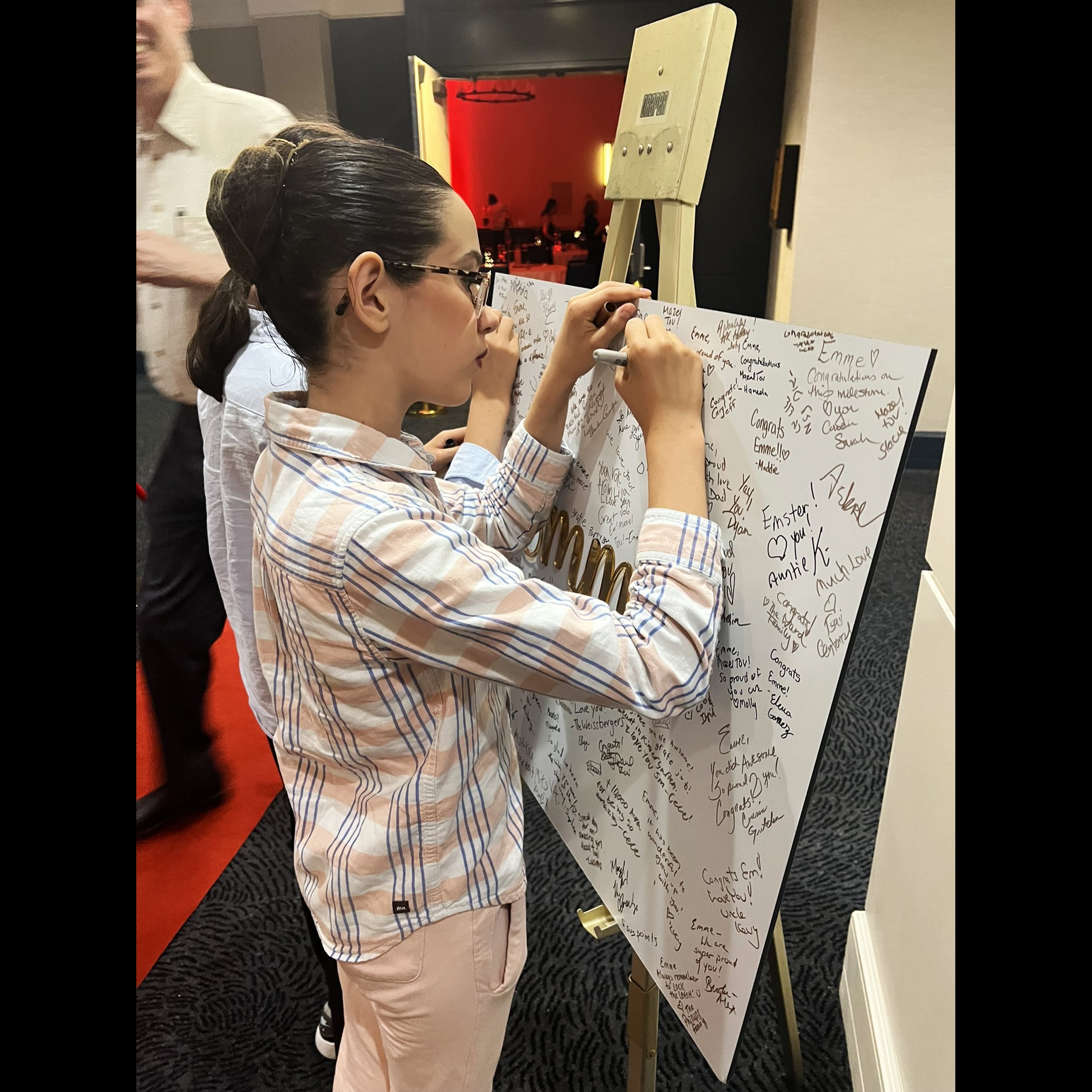 Emme Being Signed at Party.jpg