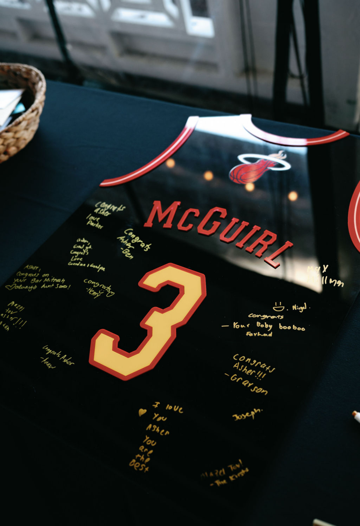 Black basketball jersey sign-in board with red and gold accents.