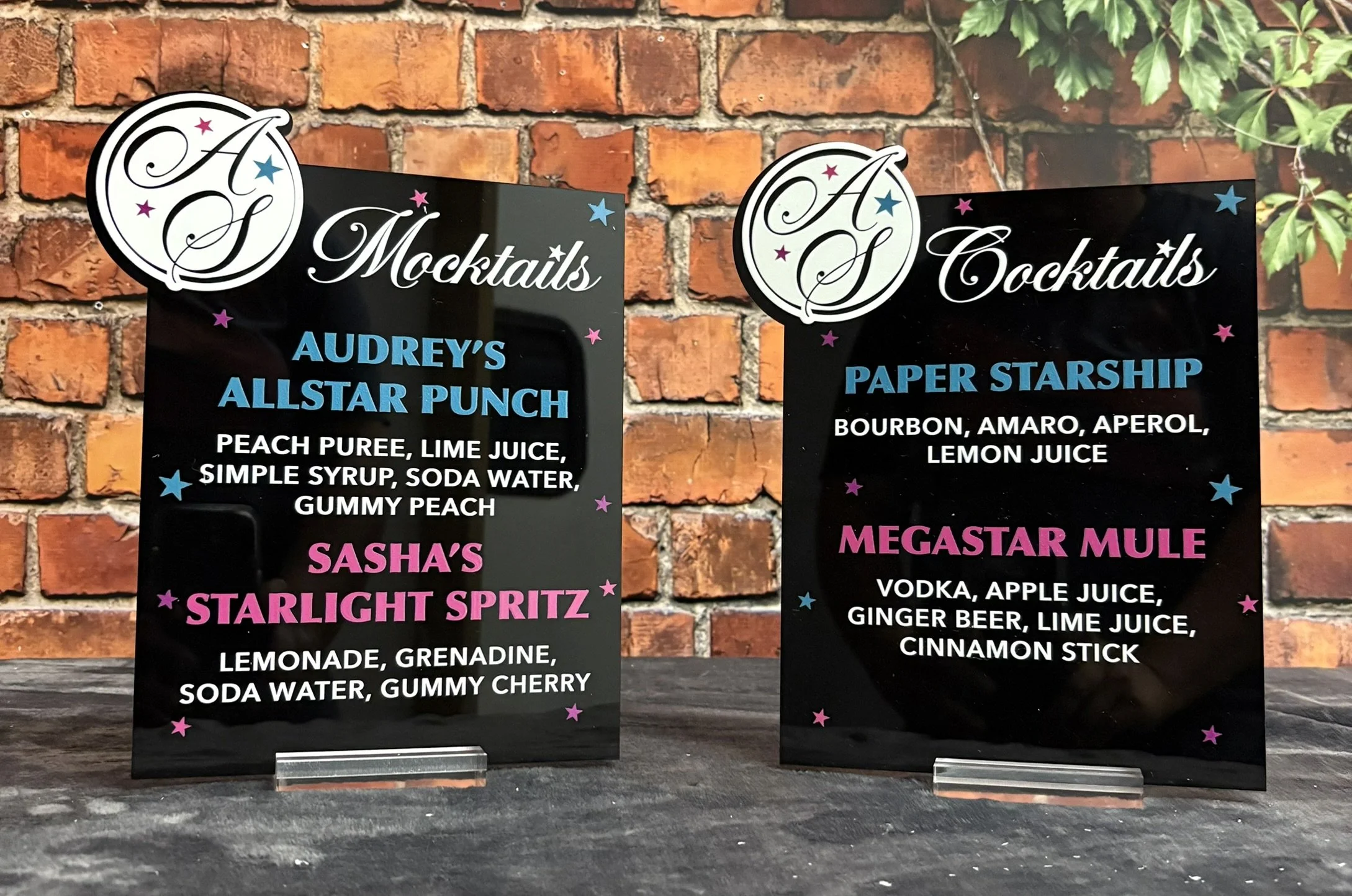 Custom black acrylic drink menu with blue and pink detailing. 