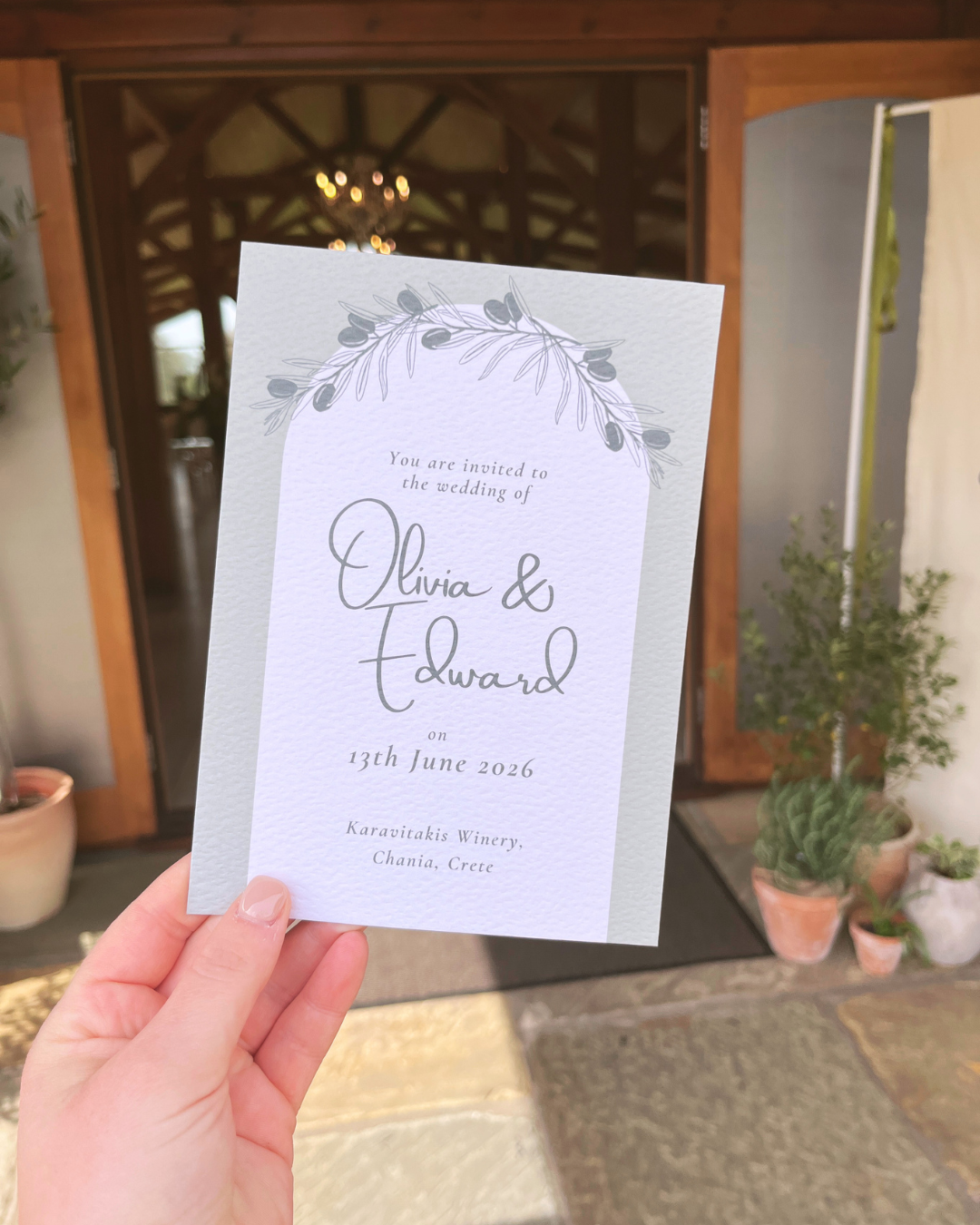 Wedding invitation card with olive design, inviting Olivia and Edward to marry on June 13, 2026, at Karavitakis Winery in Chania, Crete.