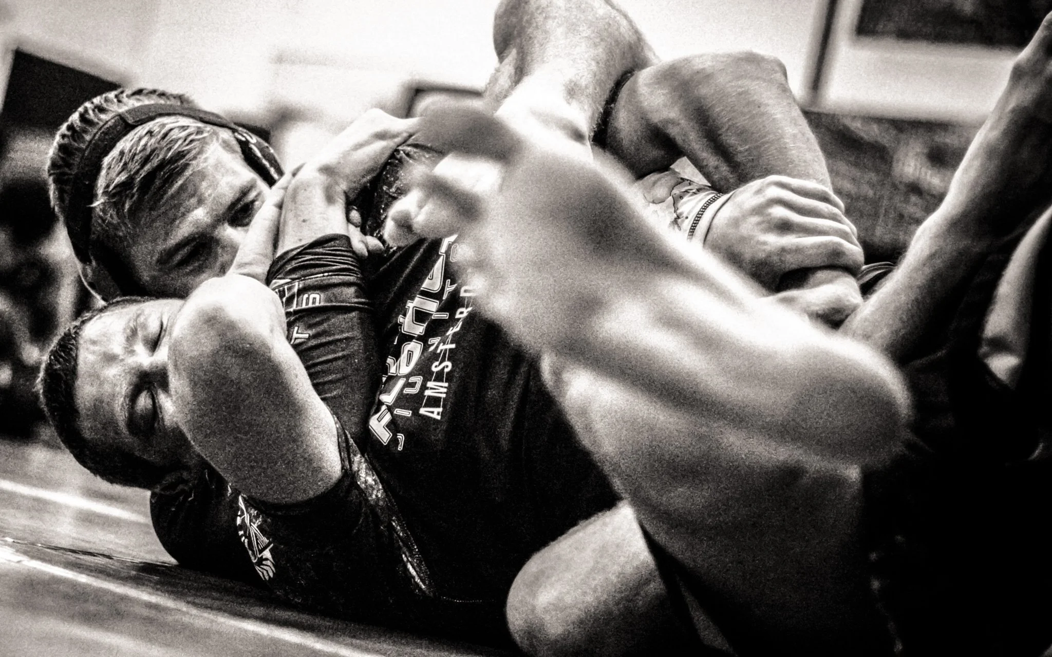 Two mixed martial arts fighters grappling on the ground in a fight.