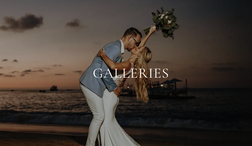 A couple in wedding attire sharing a kiss on the beach at sunset, with the woman holding a bouquet of flowers.