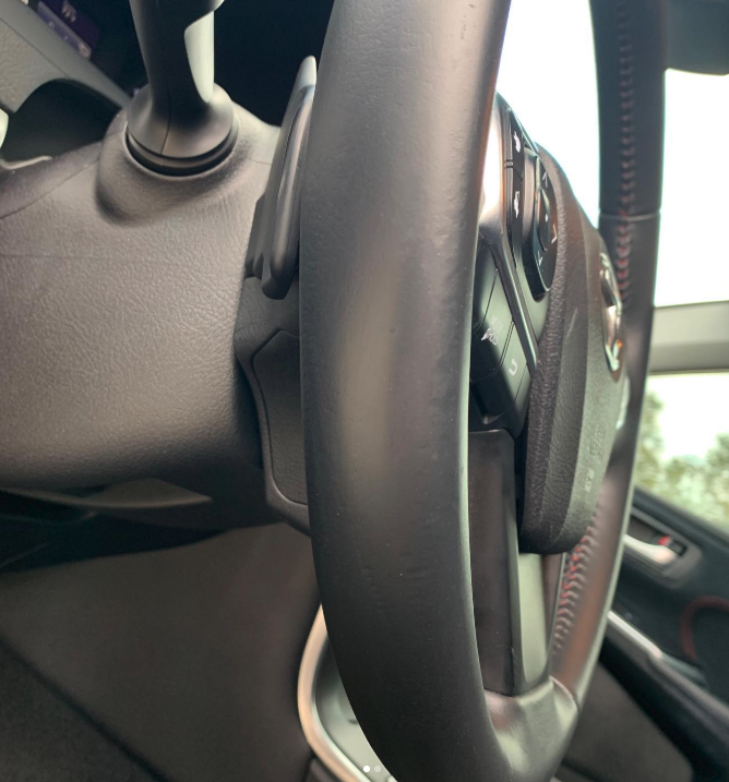 Close-up of a car's steering wheel and dashboard.