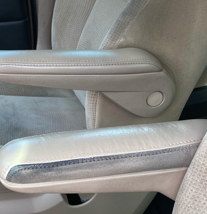 Close-up of beige leather car seats with visible stitching and armrests