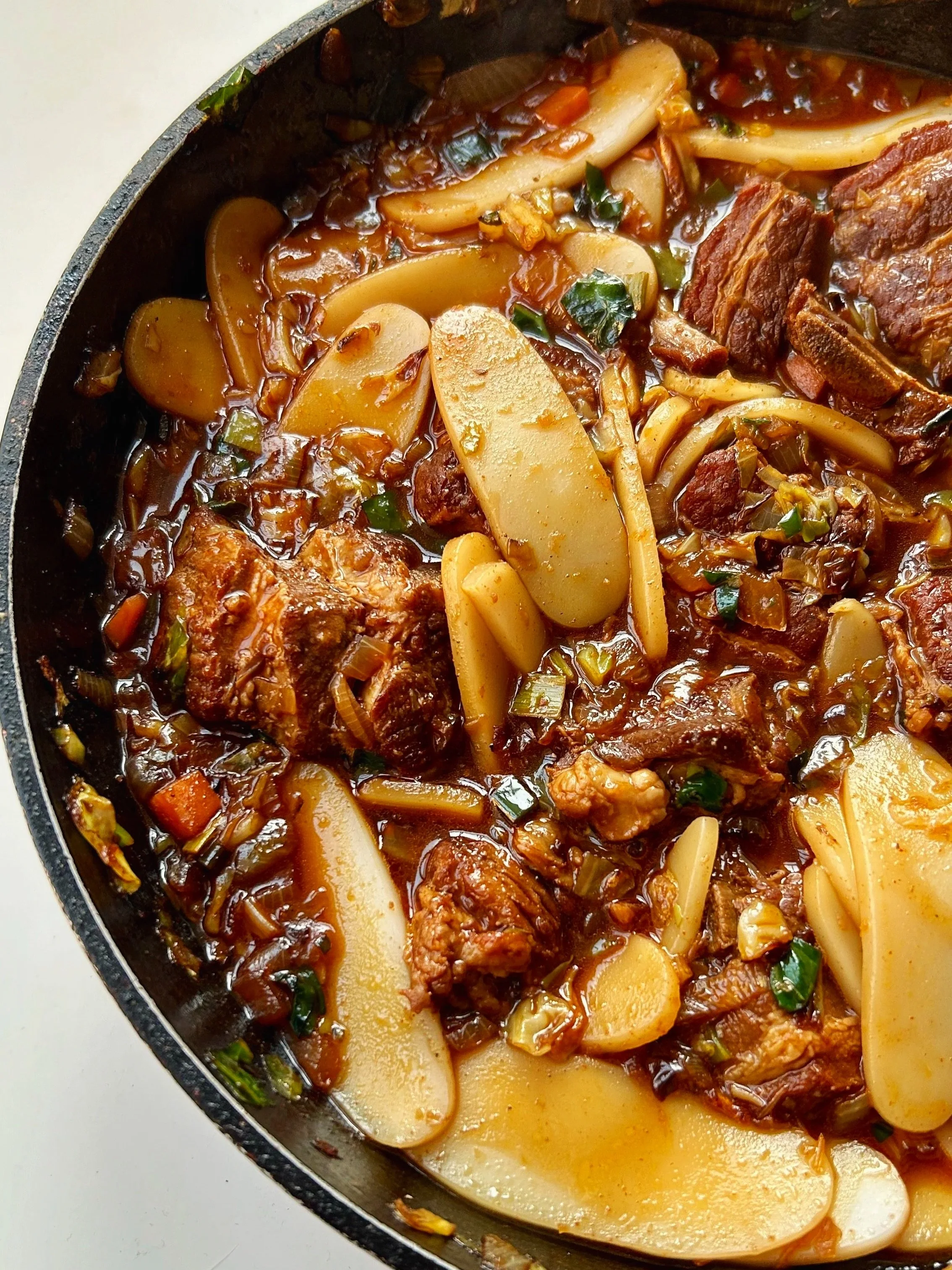 Hearty bowl of tender braised pork in a flavorful Asian-style sauce with mixed vegetables