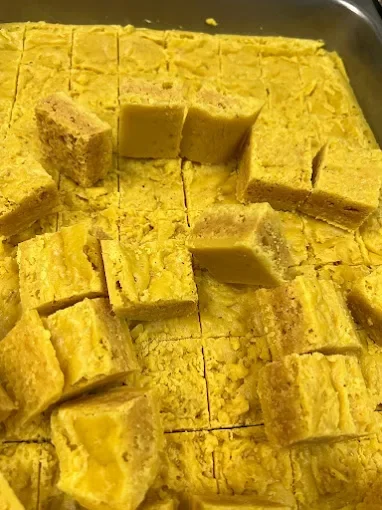Cubed yellow cornbread in a baking dish.