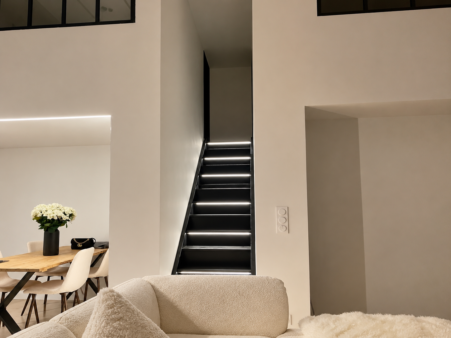Conception d'éclairages pour un escalier intérieur moderne avec éclairage LED, dans un espace minimaliste blanc.