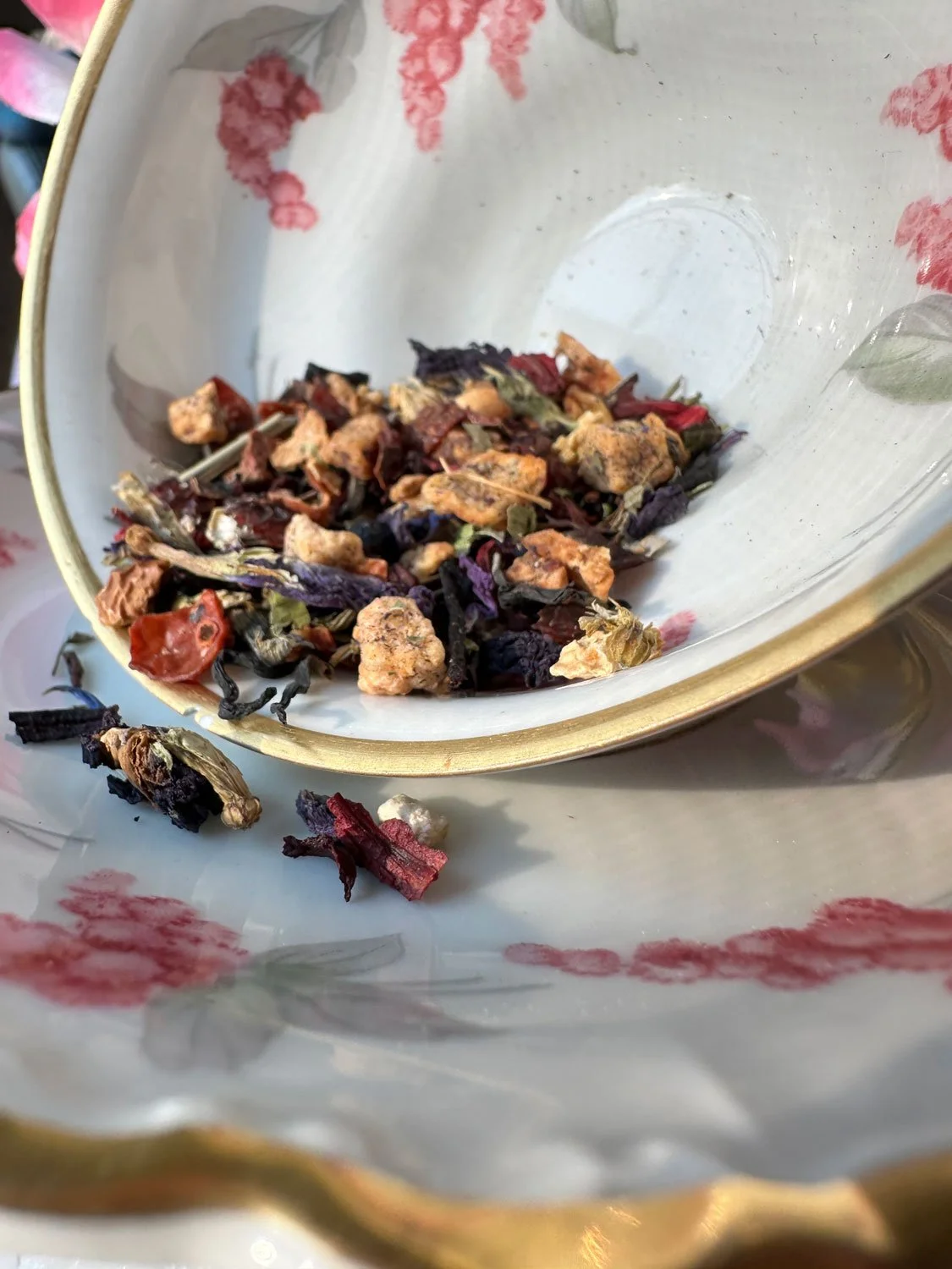 Sassy Rose's dried herbal tea ingredients in a floral-patterned teacup