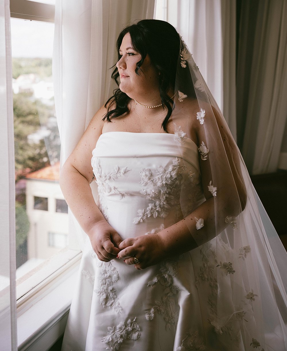 Bride looks out the window in Tower Suite, on her special day in St. Augustine, Florida.