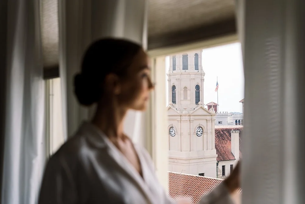 Bride looks out the window on her big day to see the whole town of St. Augustine from Tower Suite.