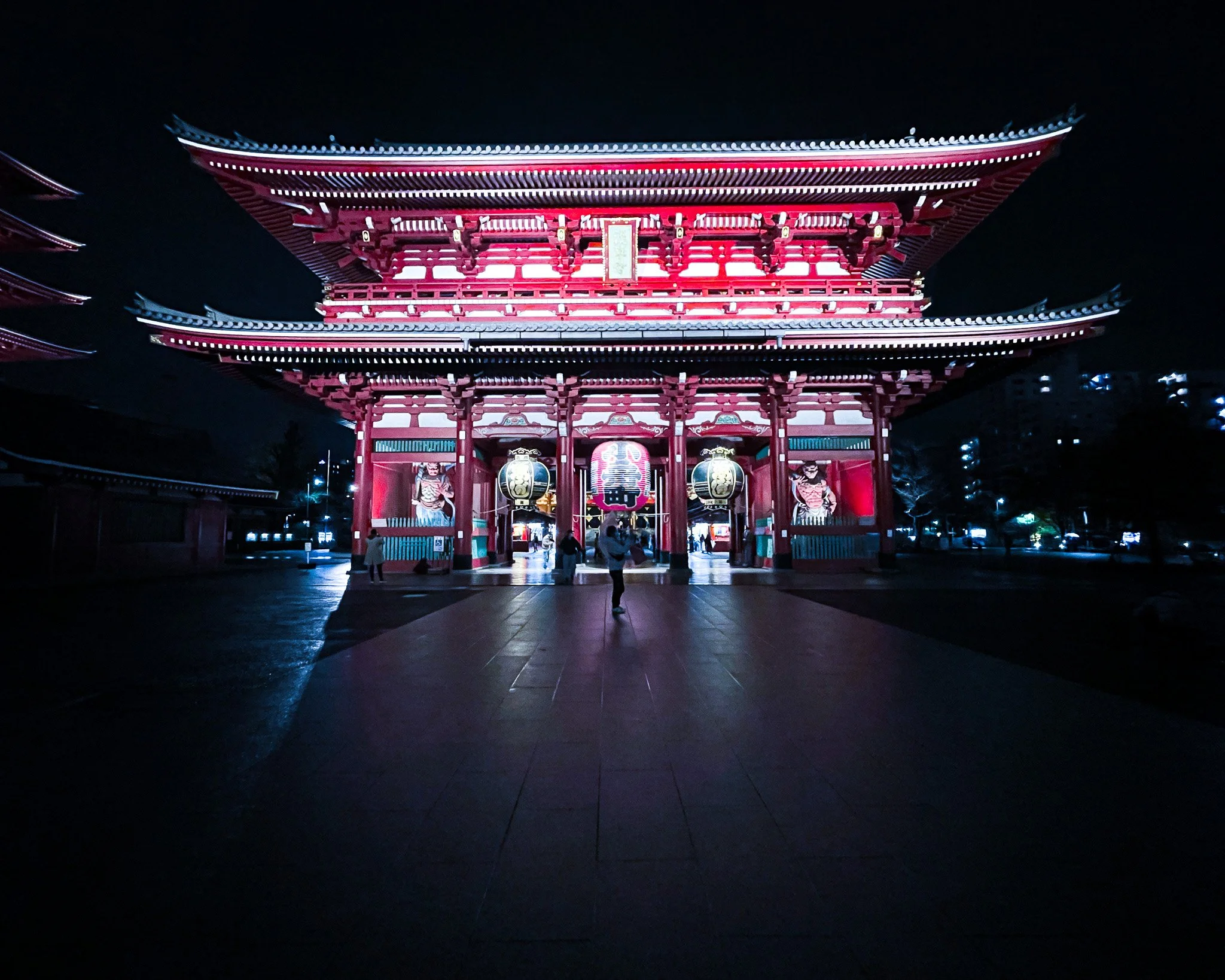 Traditional Japanese temple illuminated at night with a dark sky in the background.