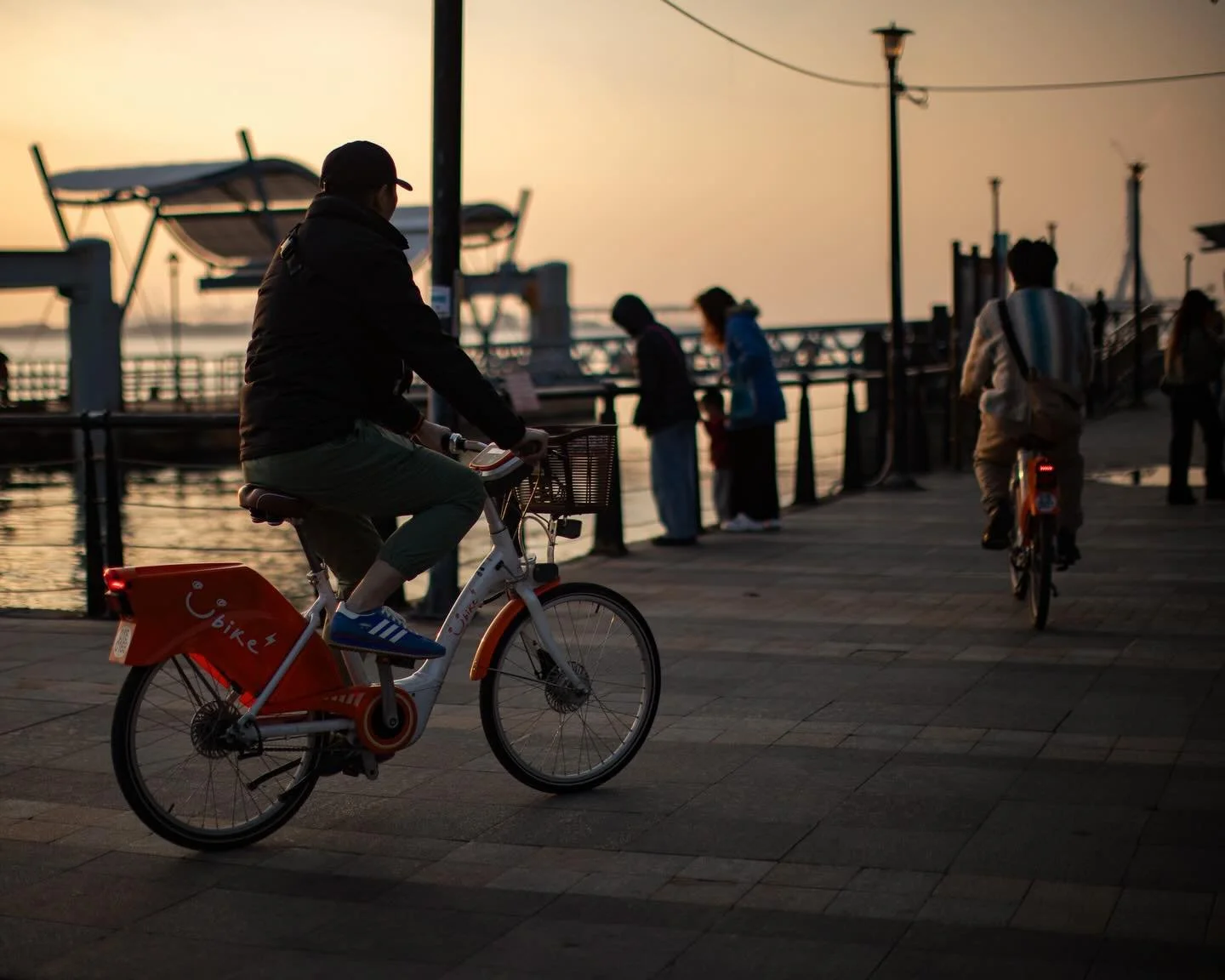 Golden 🌅 light drifts across the waterfront
as cyclists 🚴 glide like quiet thoughts&mdash;
and the evening, soft and unhurried,
holds every passing moment
as if it were a small, warm secret.

📍 淡水金色水岸邊，台北，台灣 🇹🇼

#taiwan🇹🇼 #taiwanstreetphotogra