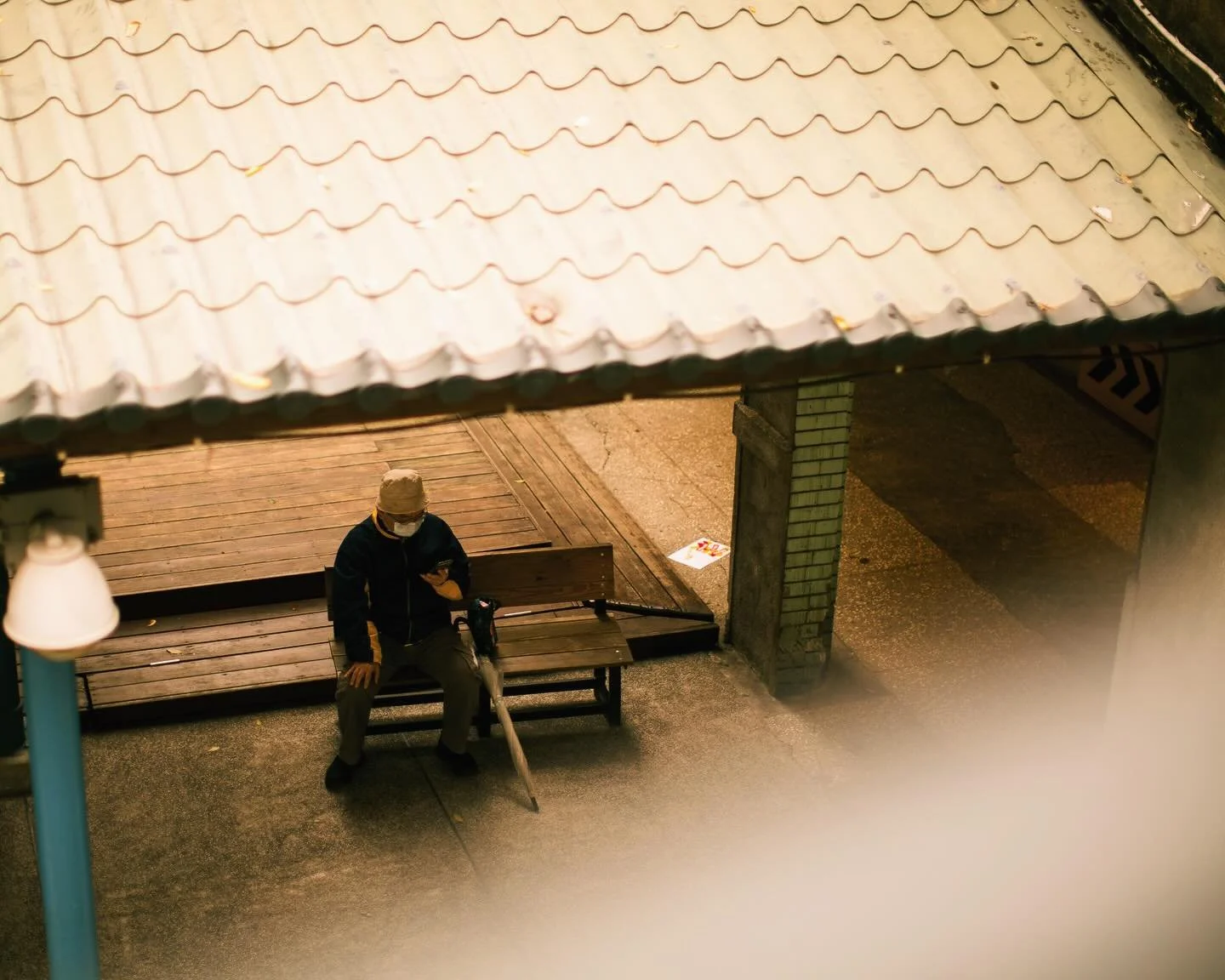 A solitary 👤figure beneath the shelter&rsquo;s muted light,
pausing between footsteps of an ordinary day&mdash;
as if the world 🌎 , for a breath,
lets him sit with the quiet
and listen to the gentle hush of passing time ⏱️.

📍Taipei 台北，Taiwan 台灣 ?