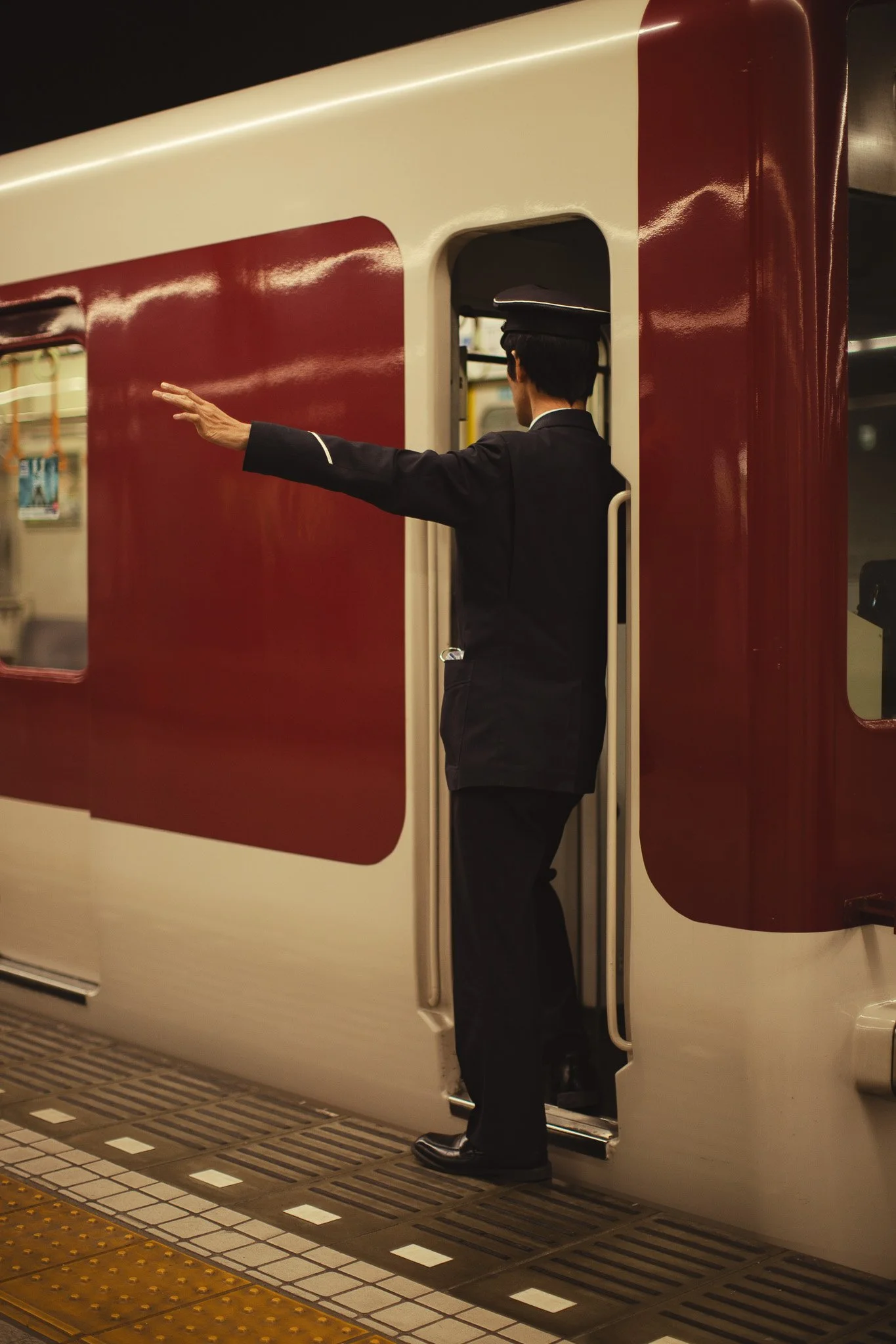kushphoto-japan-train-conductor-pointing-platform-2025.jpg