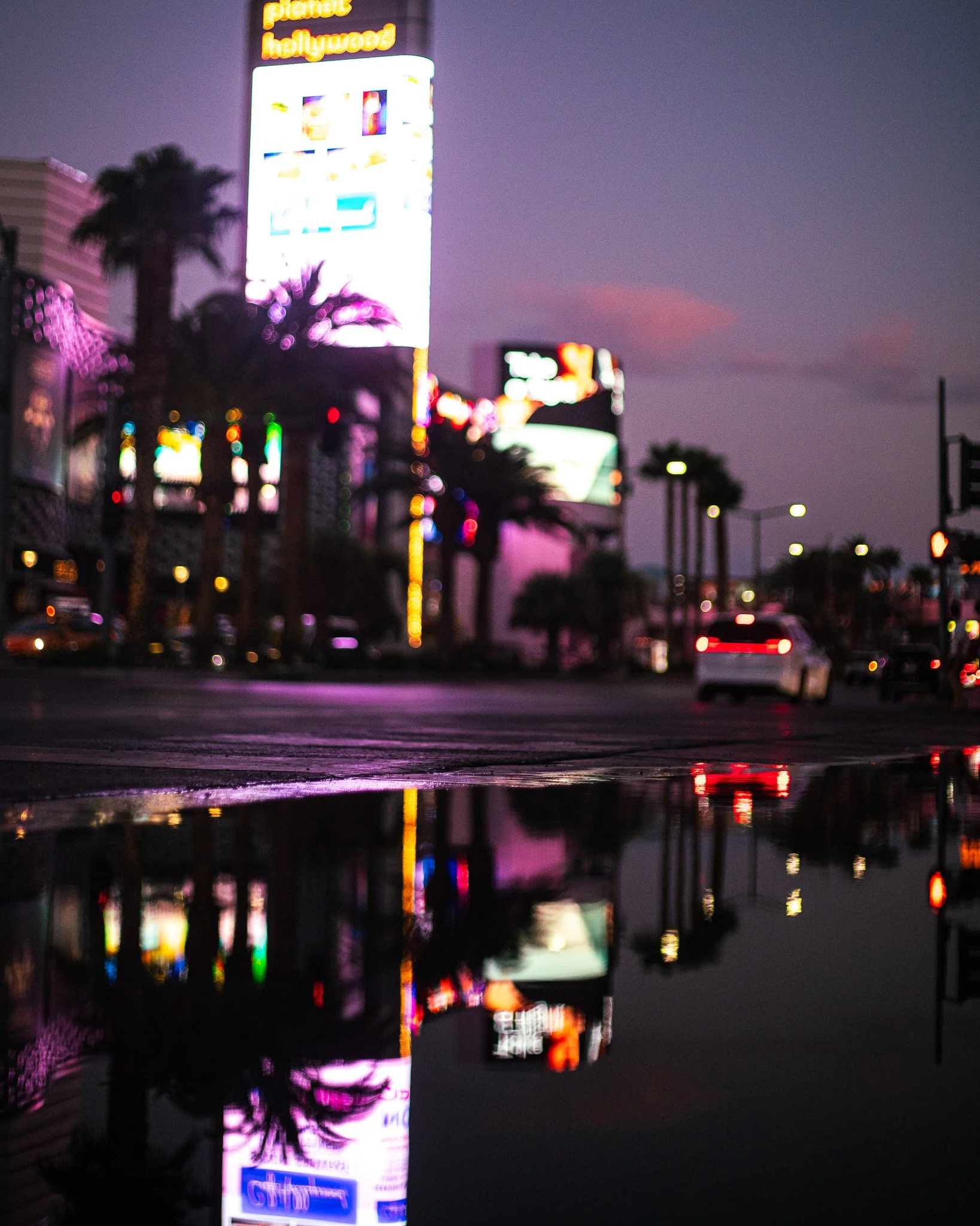 Neon lights reflected in a puddle at dusk, Las Vegas, 2023