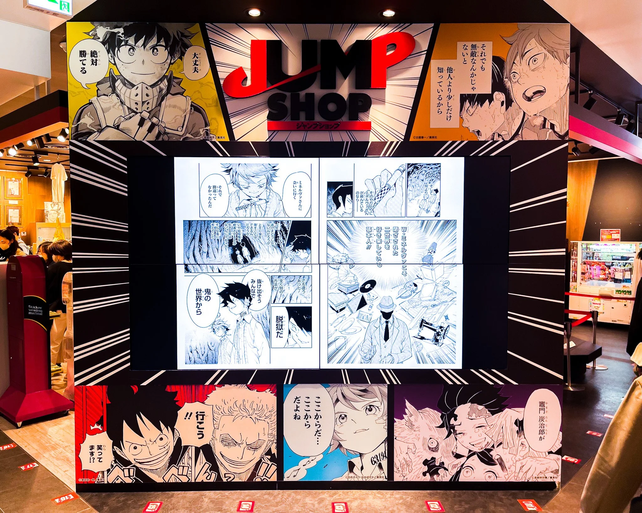 A comic strip display at Jump Shop featuring manga characters and panels, with a large digital screen showing manga scenes and colorful branding at the top.